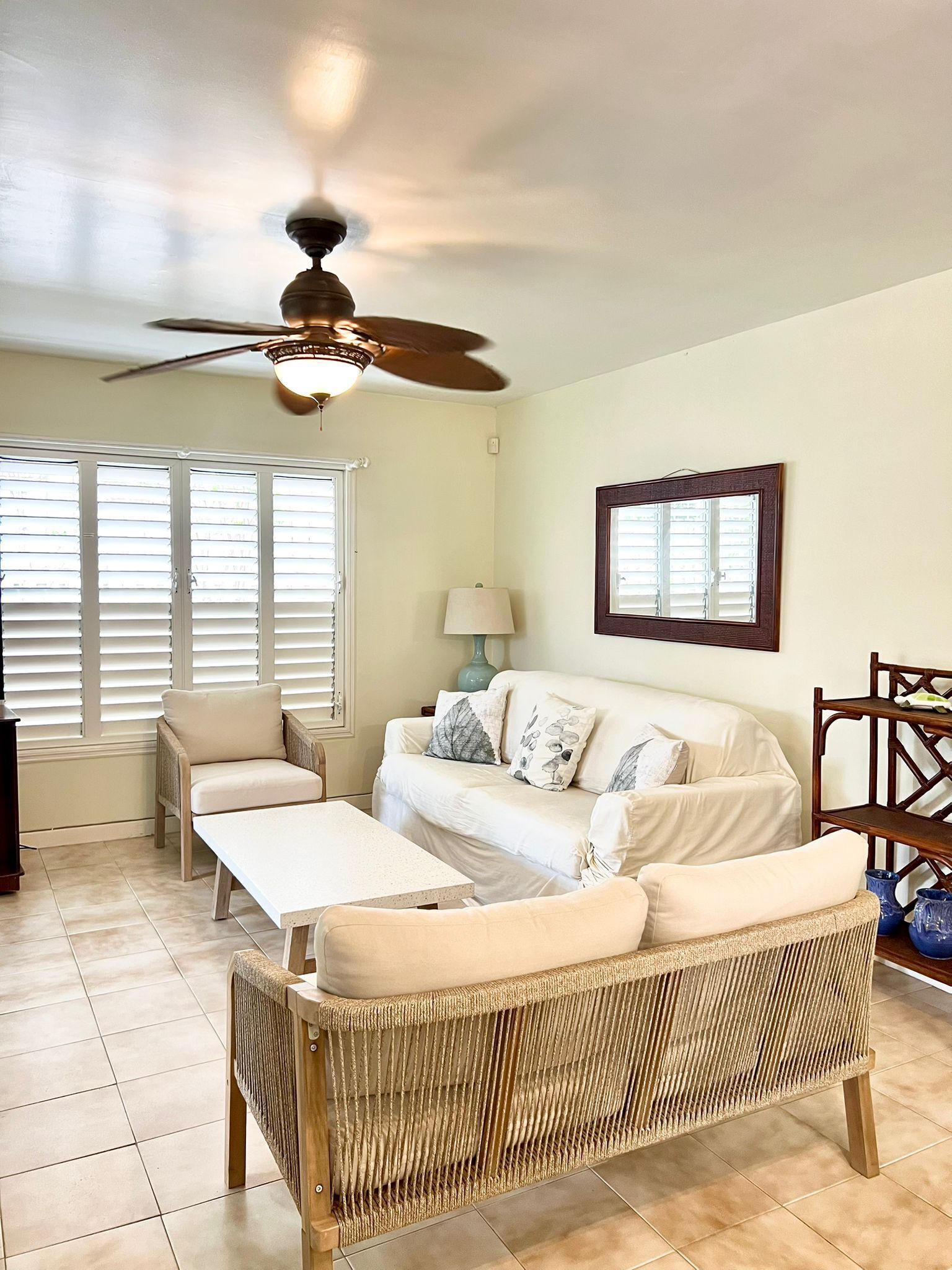 A living room with a ceiling fan and two sofas.
