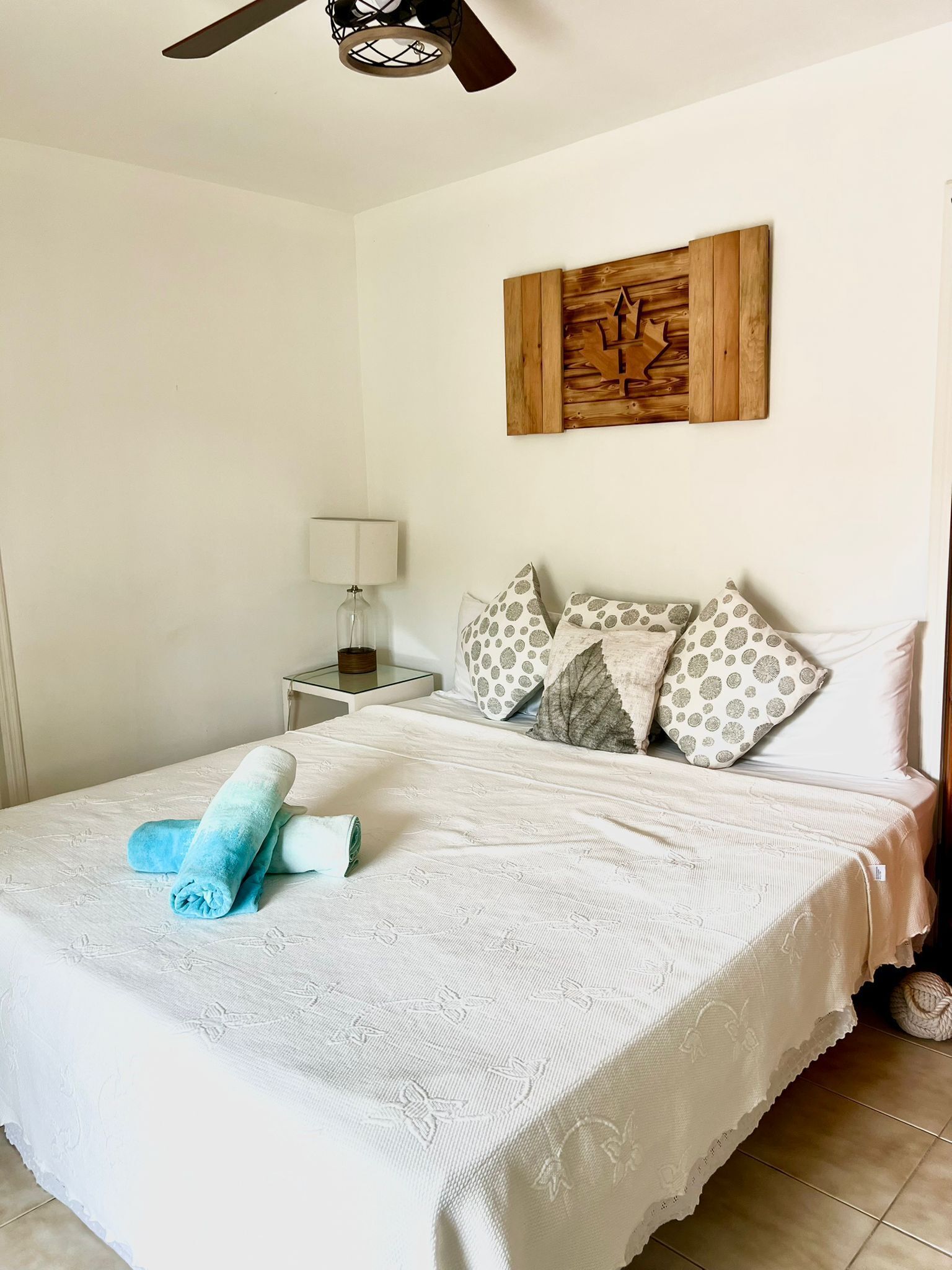 A bedroom with a double bed and rolled beach towels.