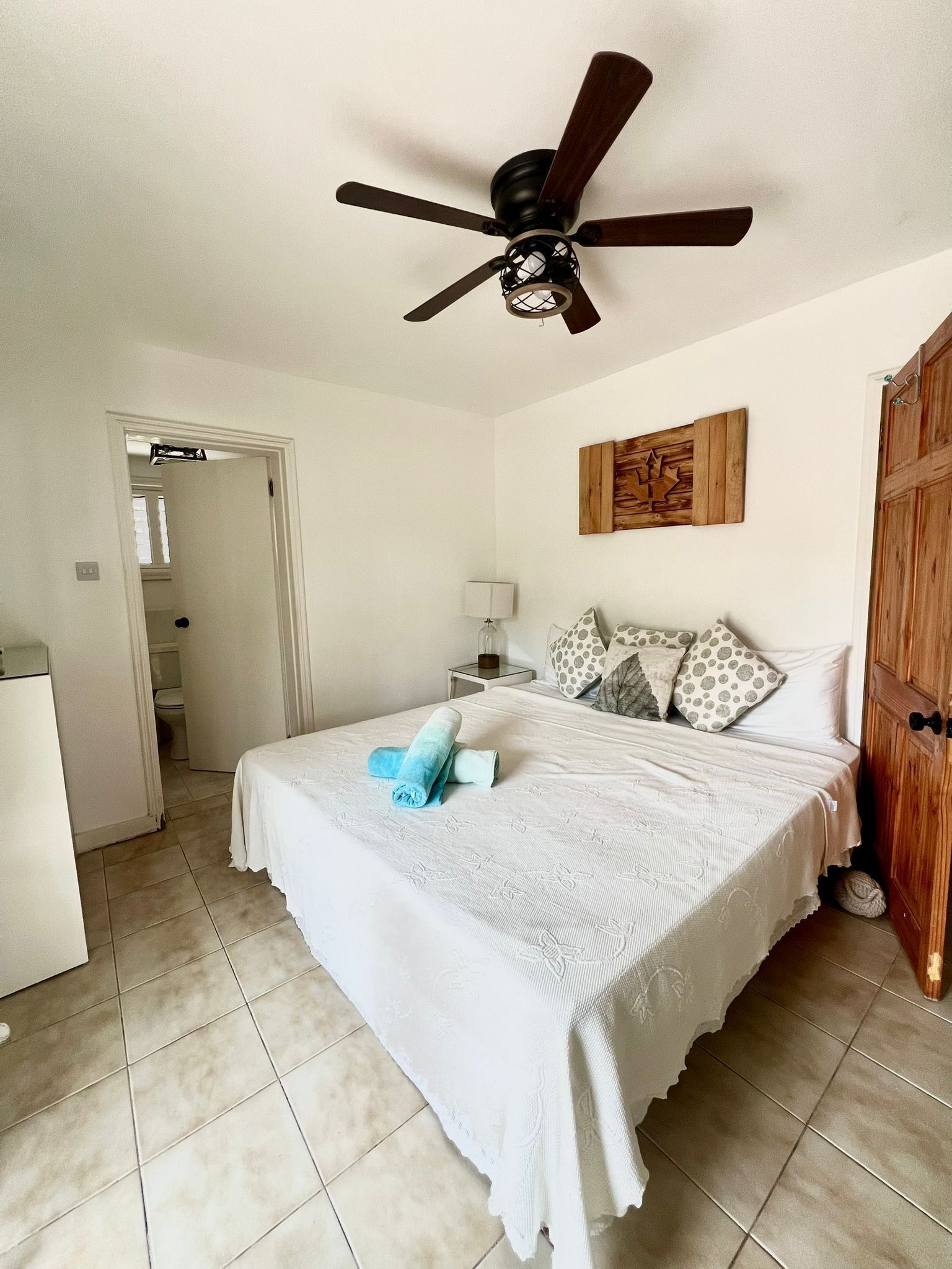 A bedroom with a double bed and a door to the bathroom.