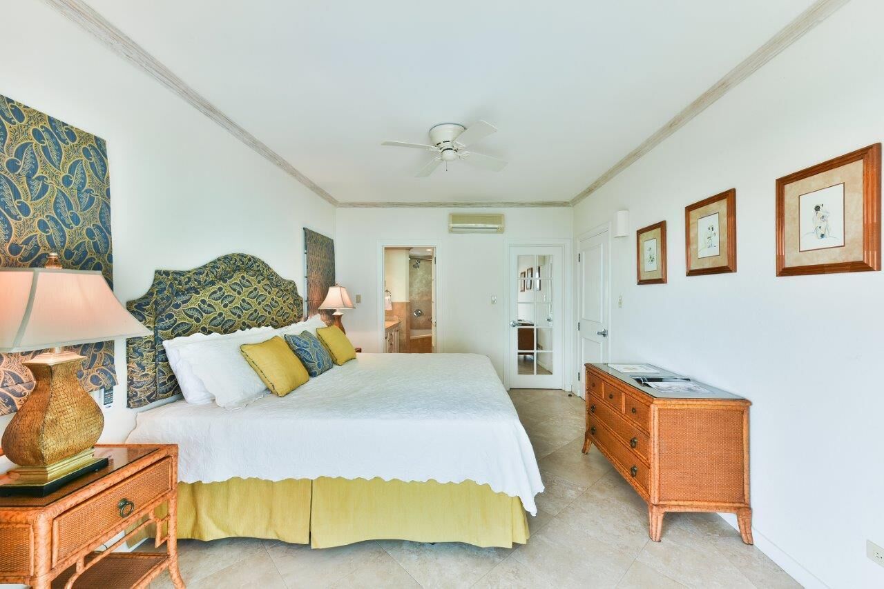 A bedroom with a wide bed and a wicker dresser.