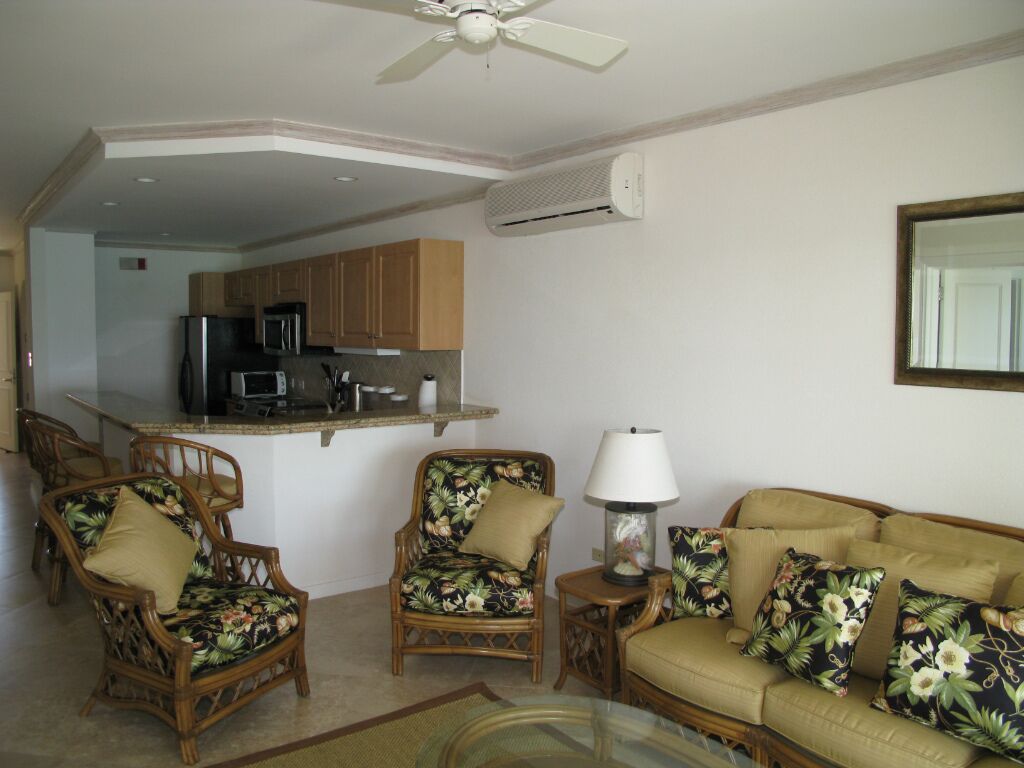 The living room with wicker seats, next to the kitchen.