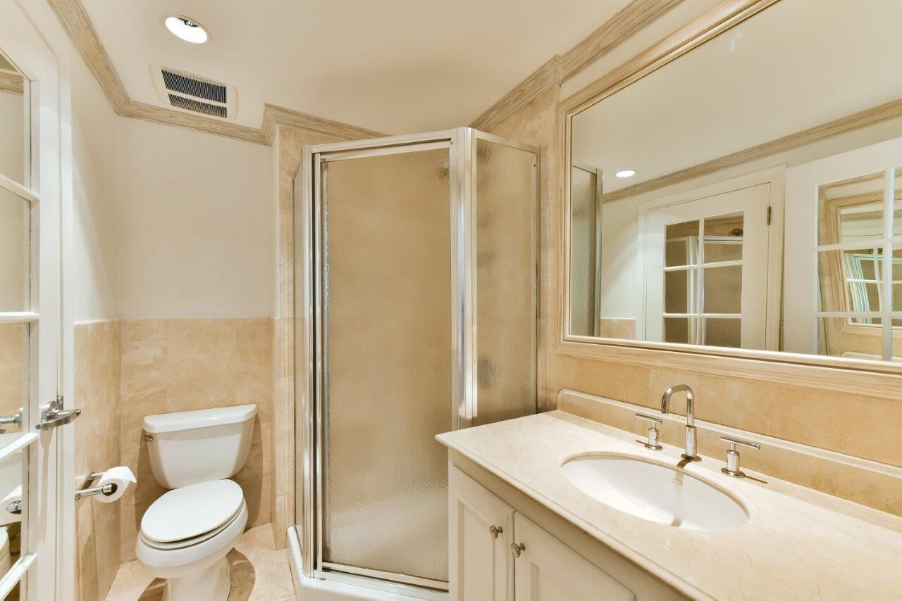A bathroom with a shower stall, a toilet, and a sink.
