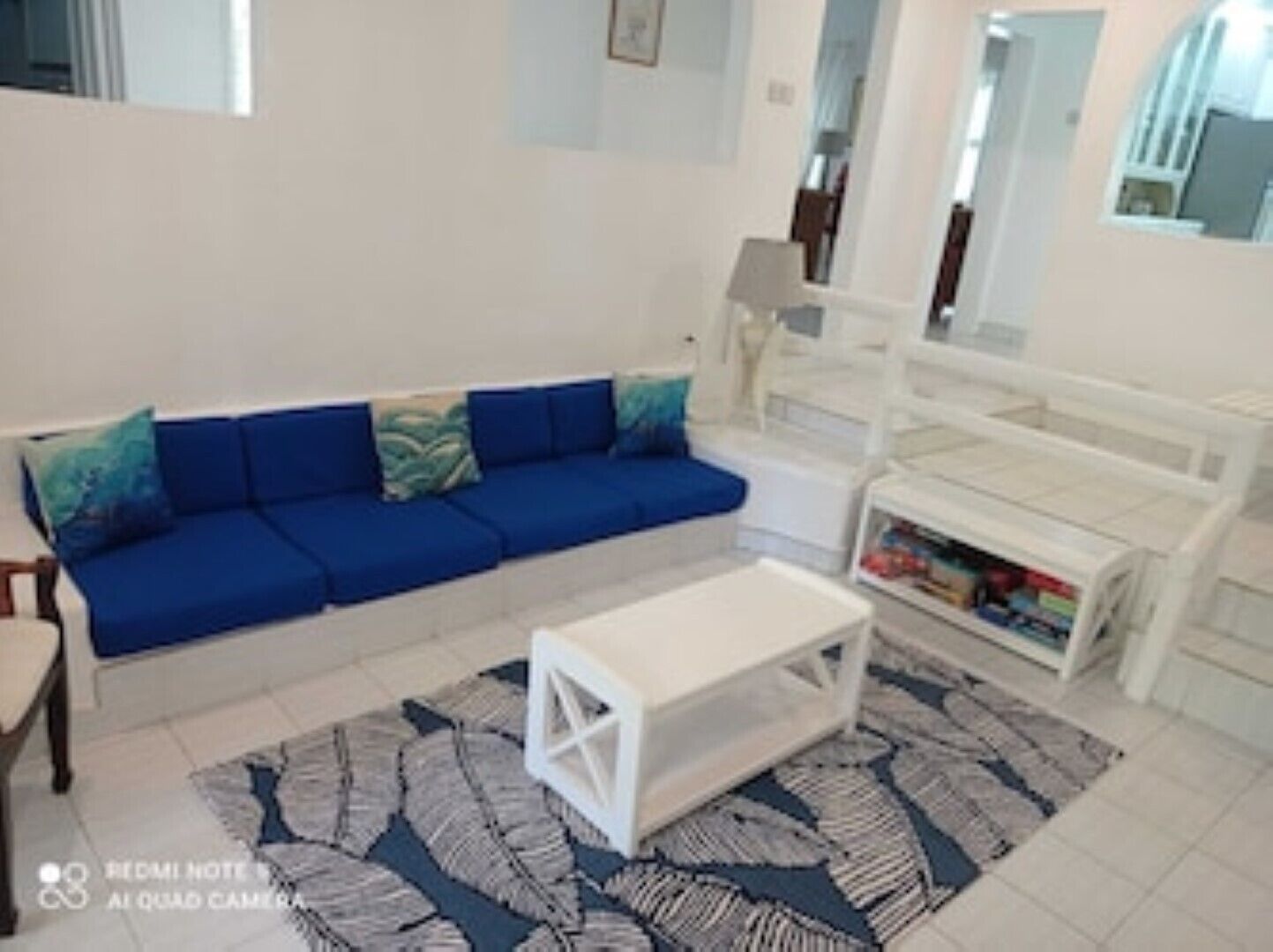A living room with a blue sofa and a white coffee table.
