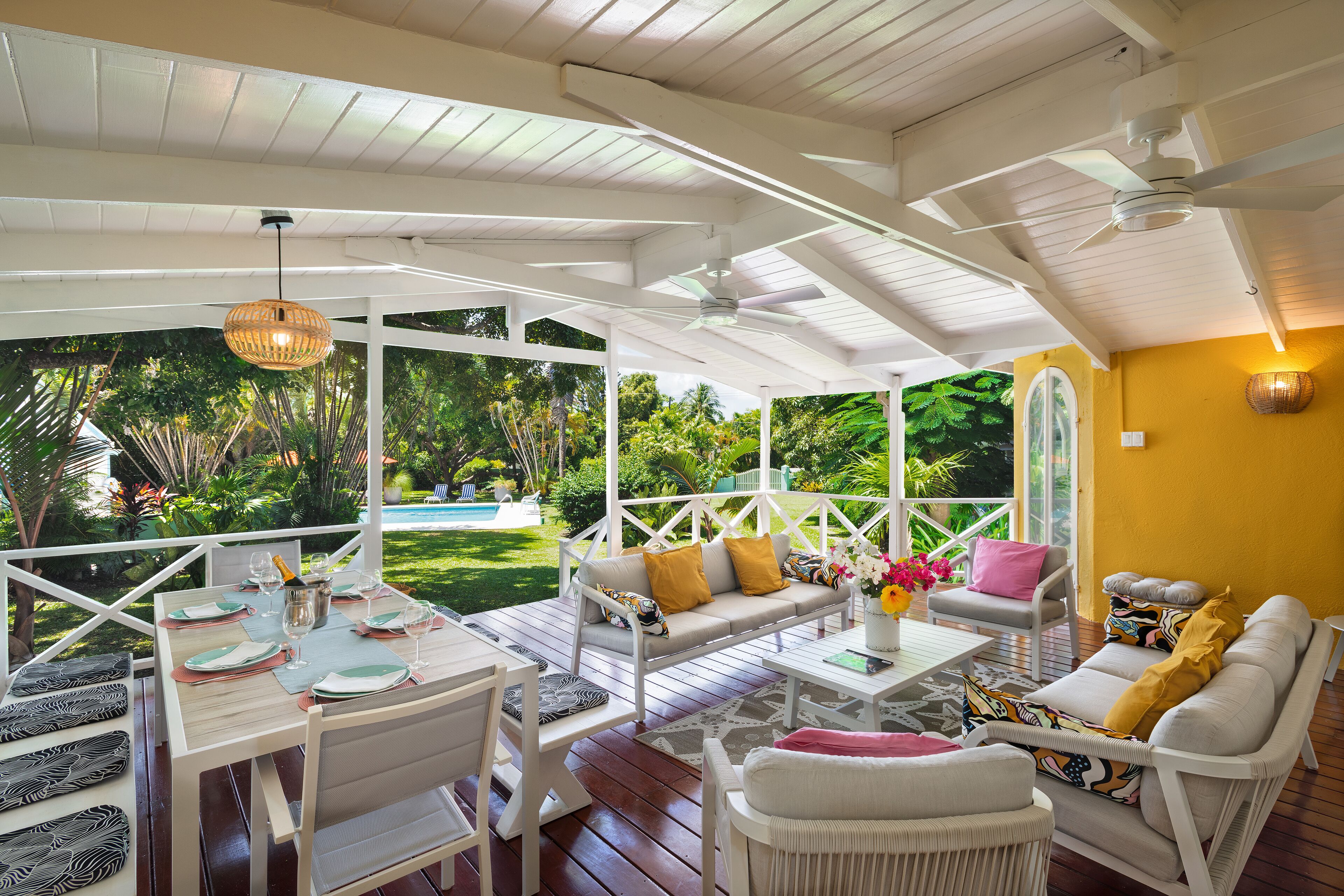 The veranda with a dining table and a view of the pool.