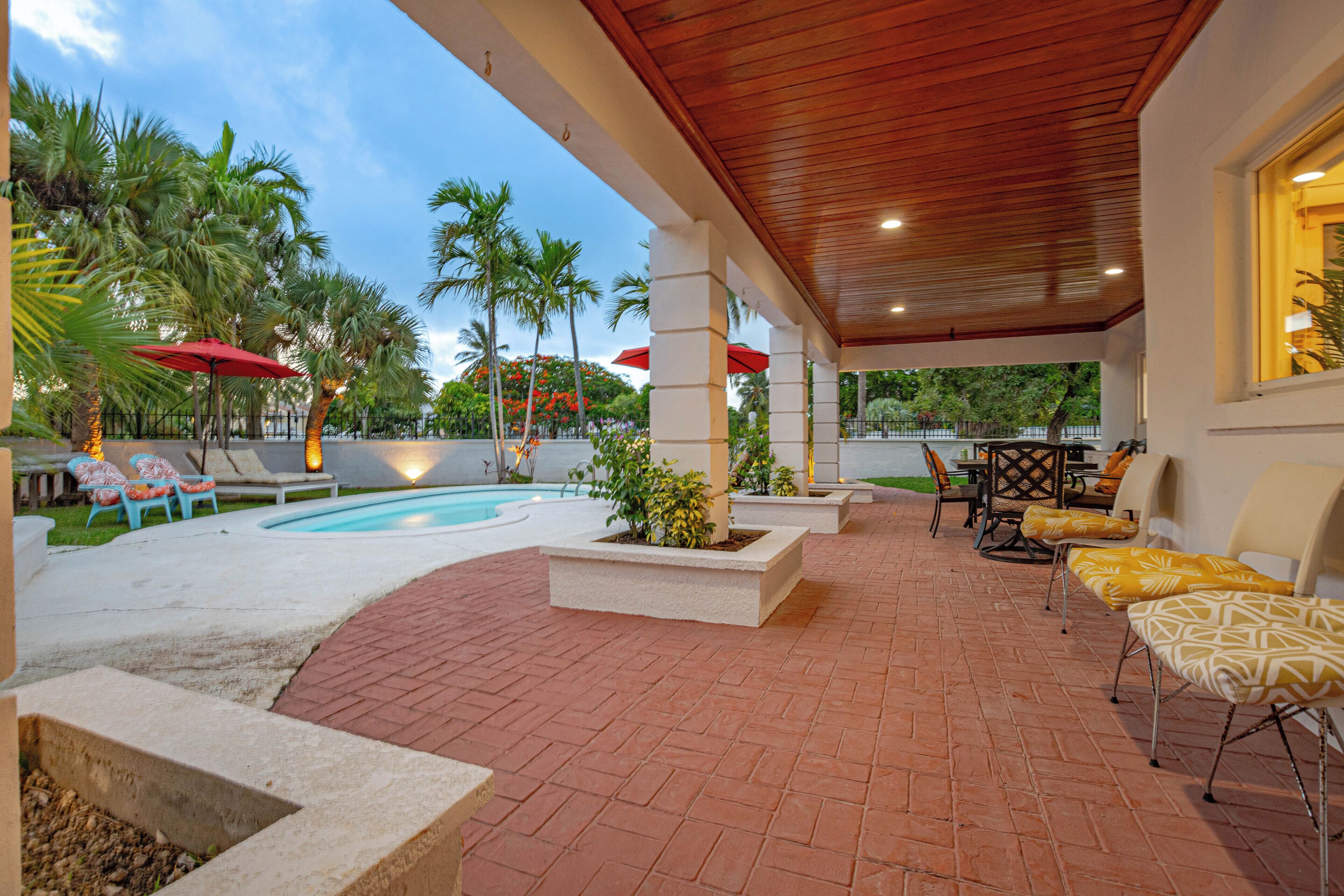 The patio with a wood ceiling and the pool.