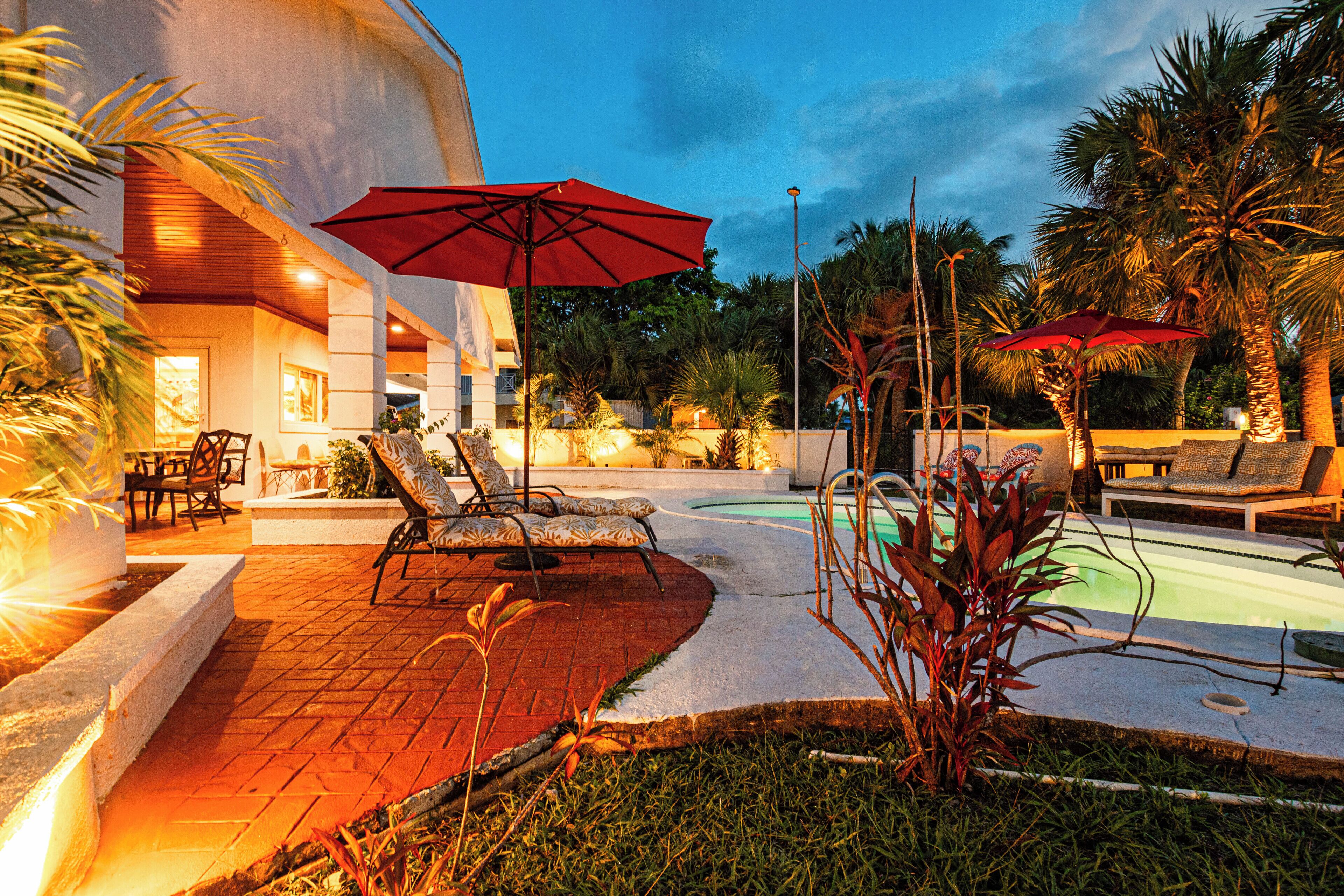The patio with lounge chairs and the pool at dusk.