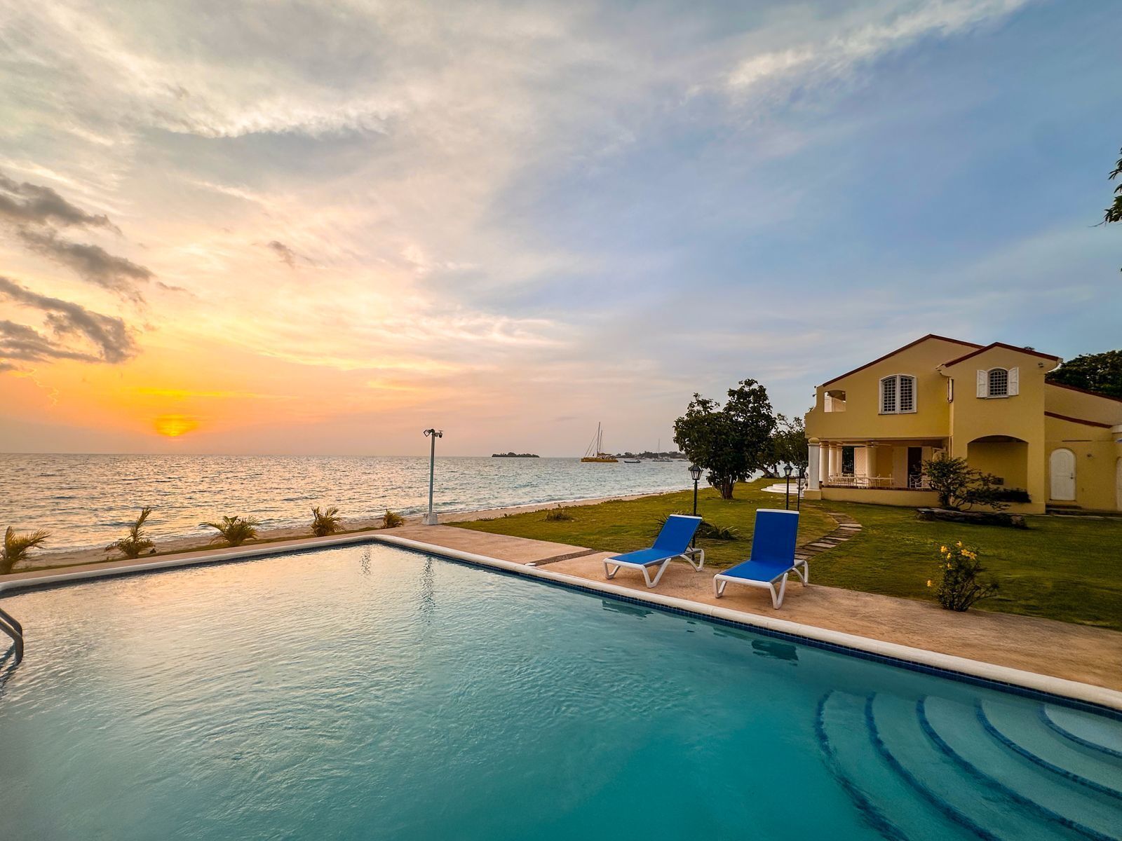 The pool at sunset with the sea and the villa on the right.