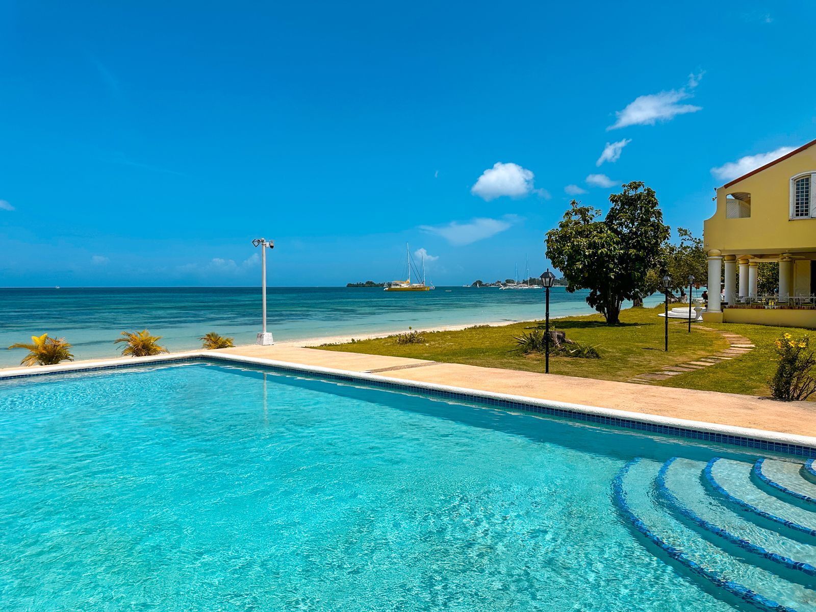 The pool beside the beach with the sea and the villa on the right.