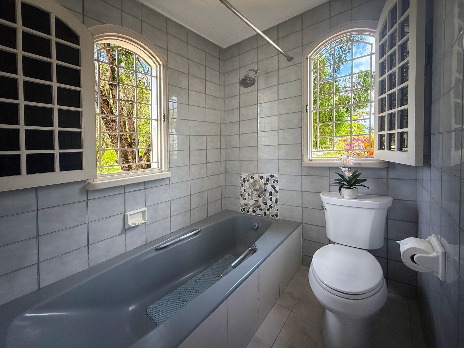 A bathroom with a tub, a shower, and a toilet.