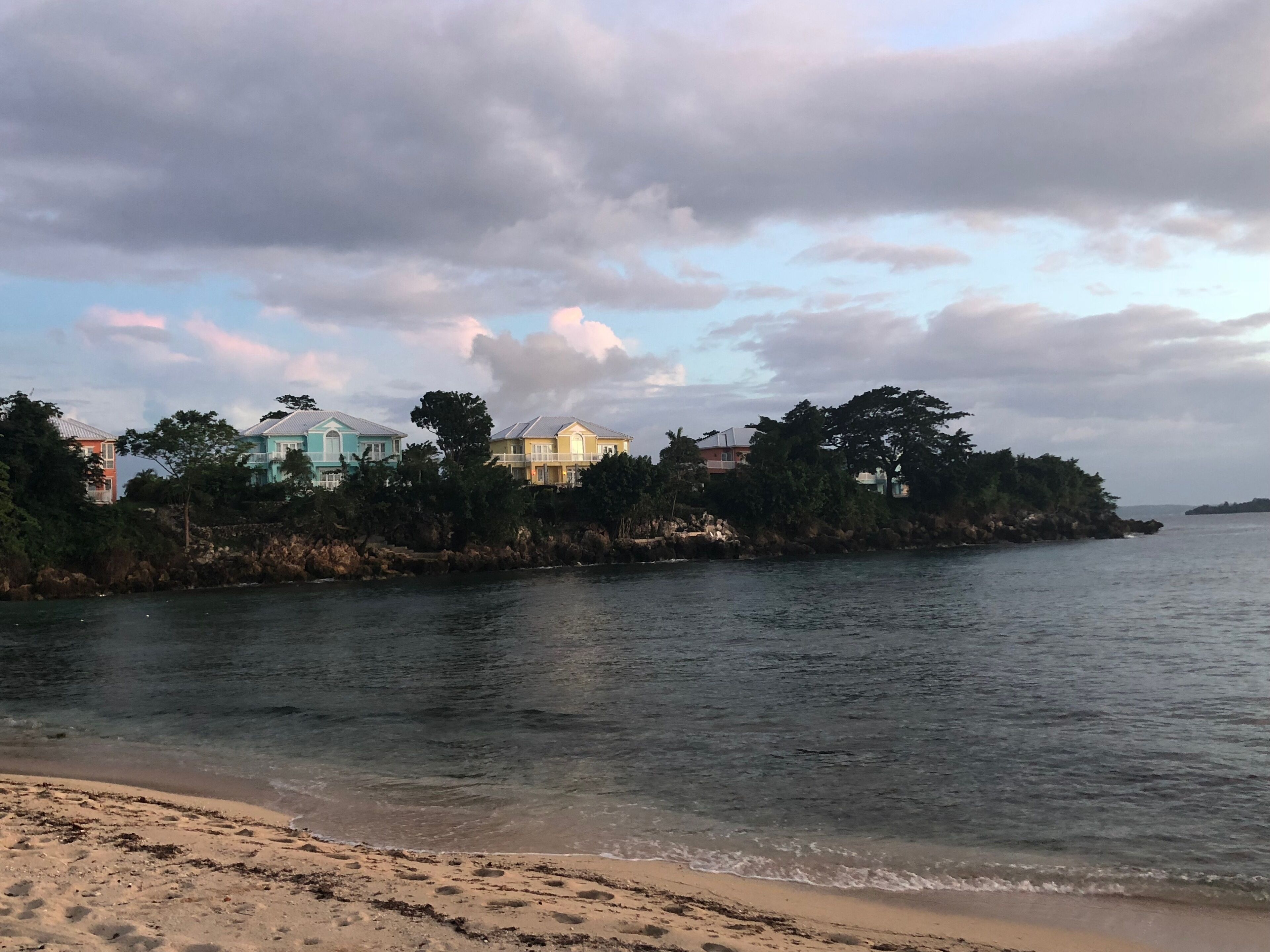 Townhomes stand on a rock point beside a small bay.