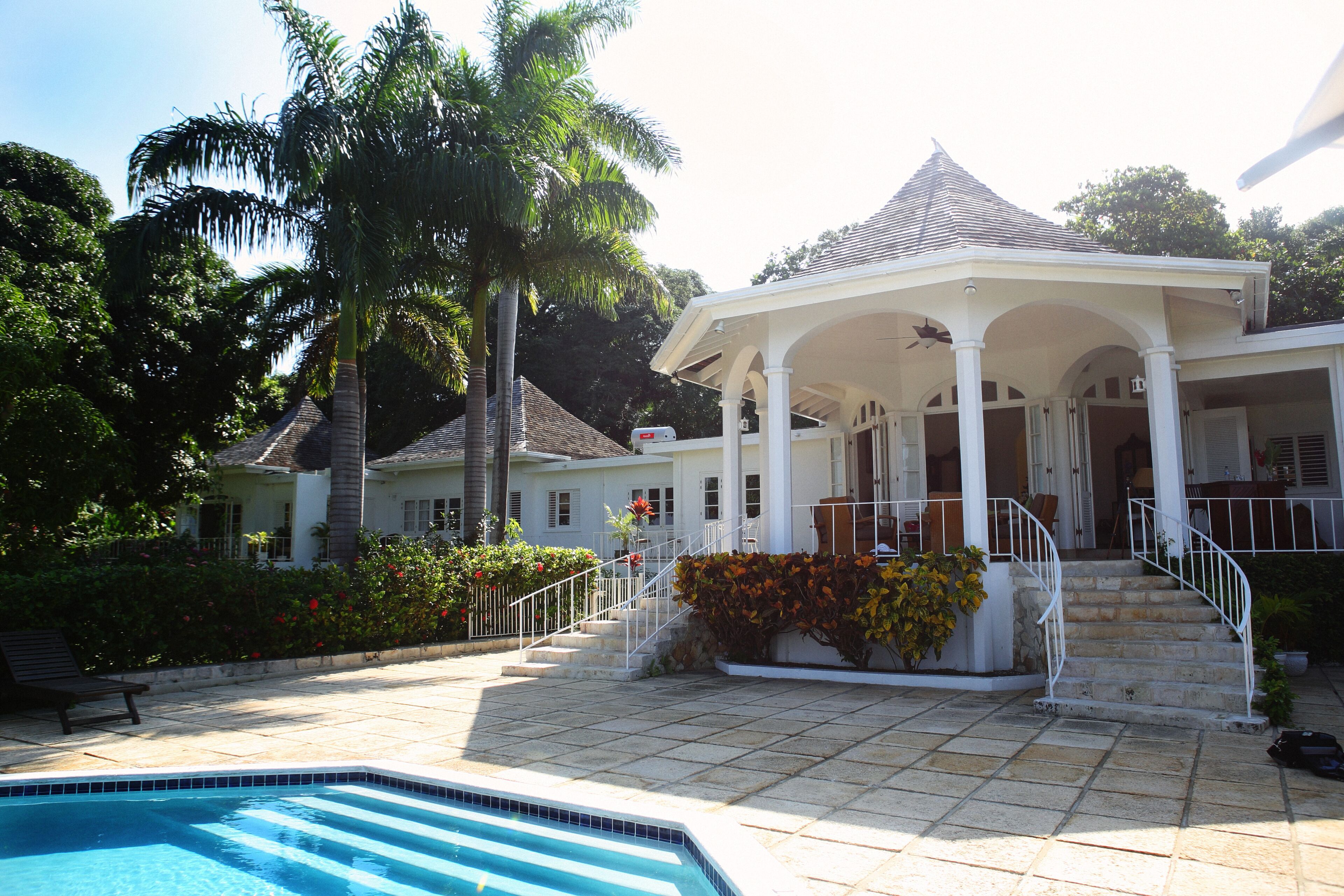 The pool terrace, the curved steps, and the covered veranda of the villa.