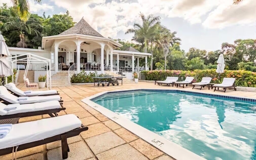 Lounge chairs around the pool in front of the villa.