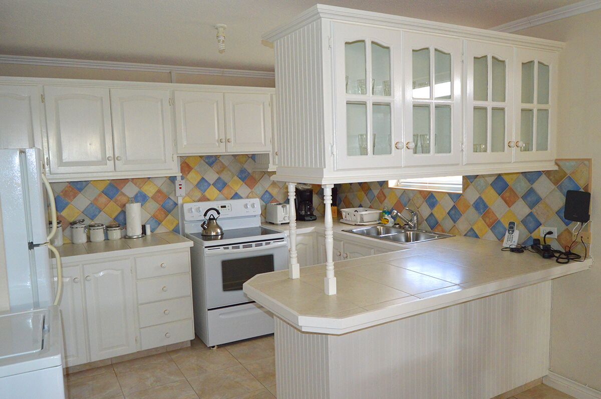 The kitchen with white cabinets, a stove, and a counter.