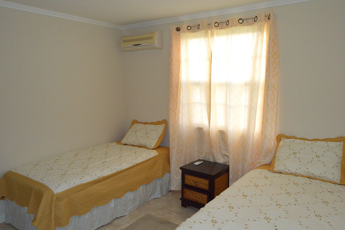 A bedroom with two single beds and a bedside table.