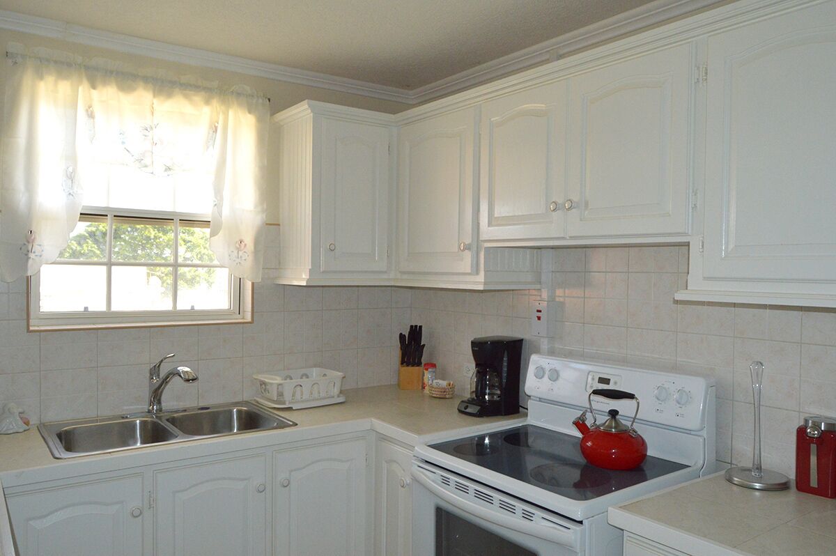 The kitchen with a double sink, a coffee maker, and a stove.