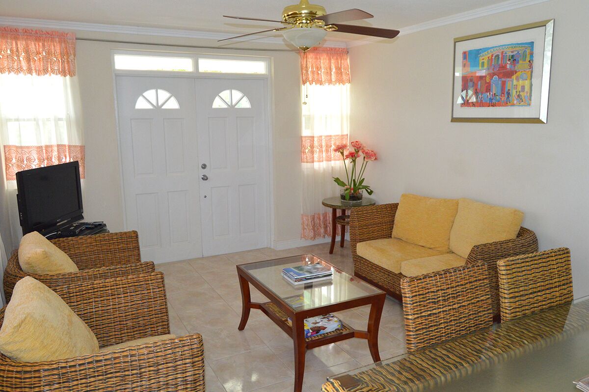 The living room with wicker sofas and a coffee table.
