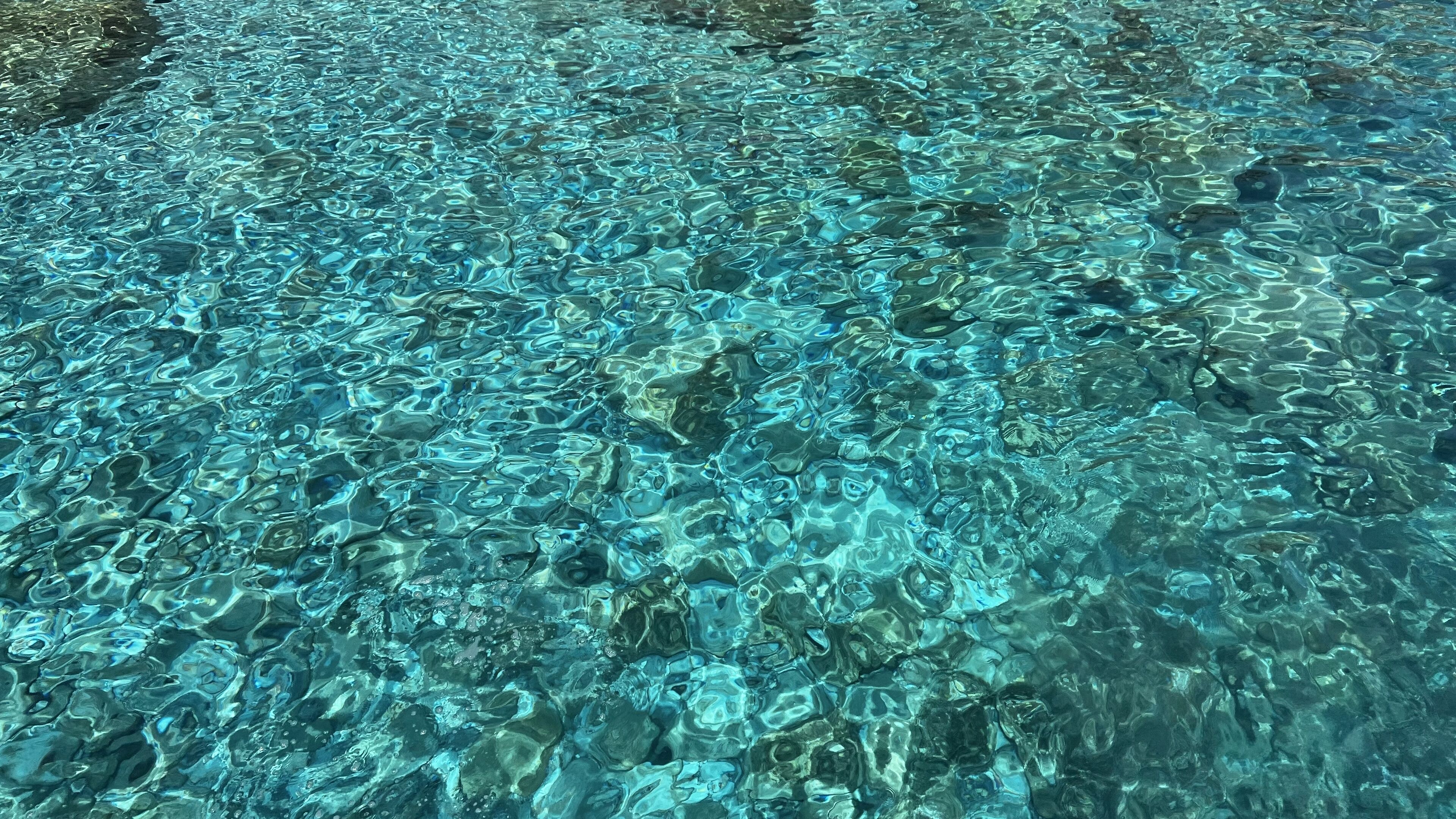 Clear turquoise water over rocks near the shore.