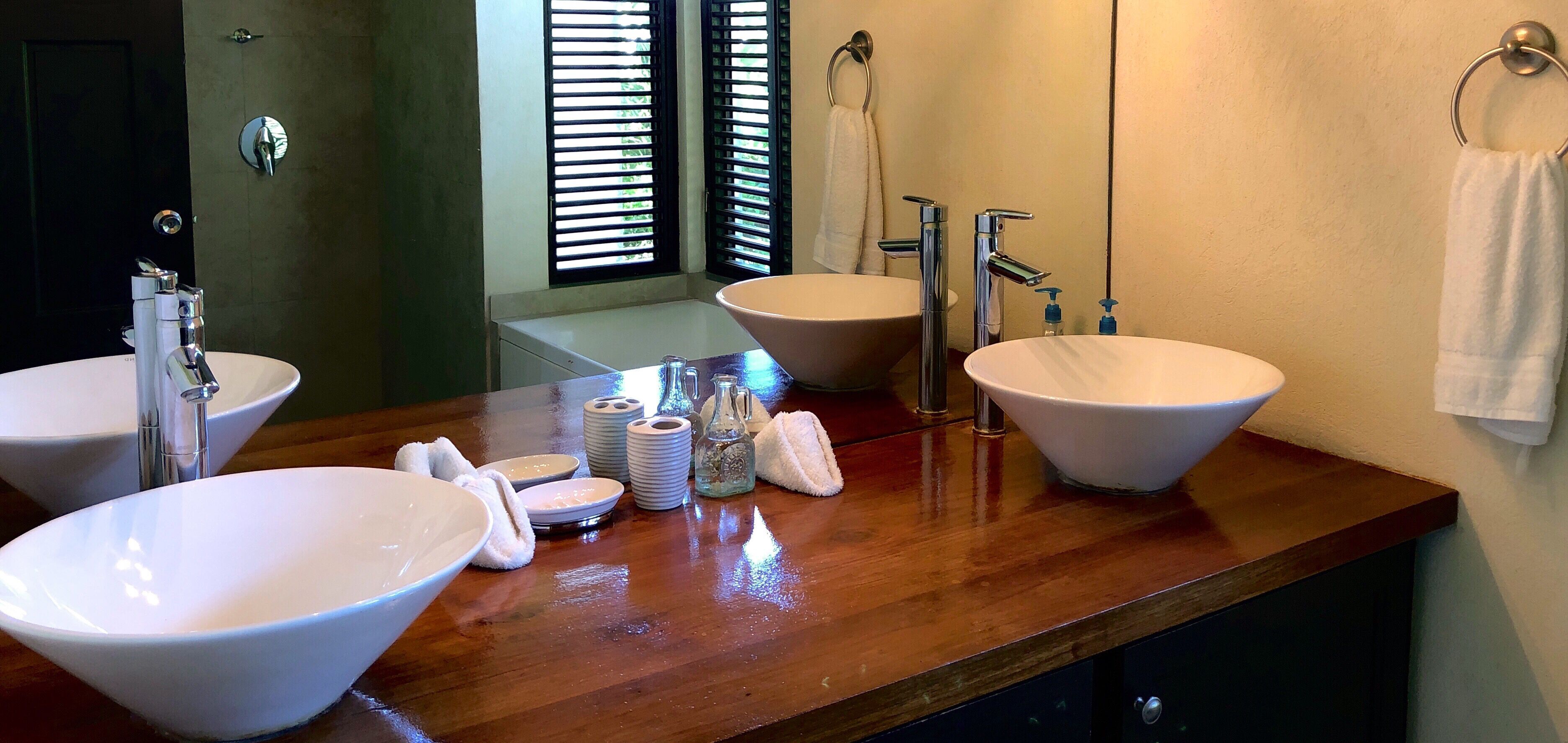 A bathroom with two basin sinks on a wood counter.