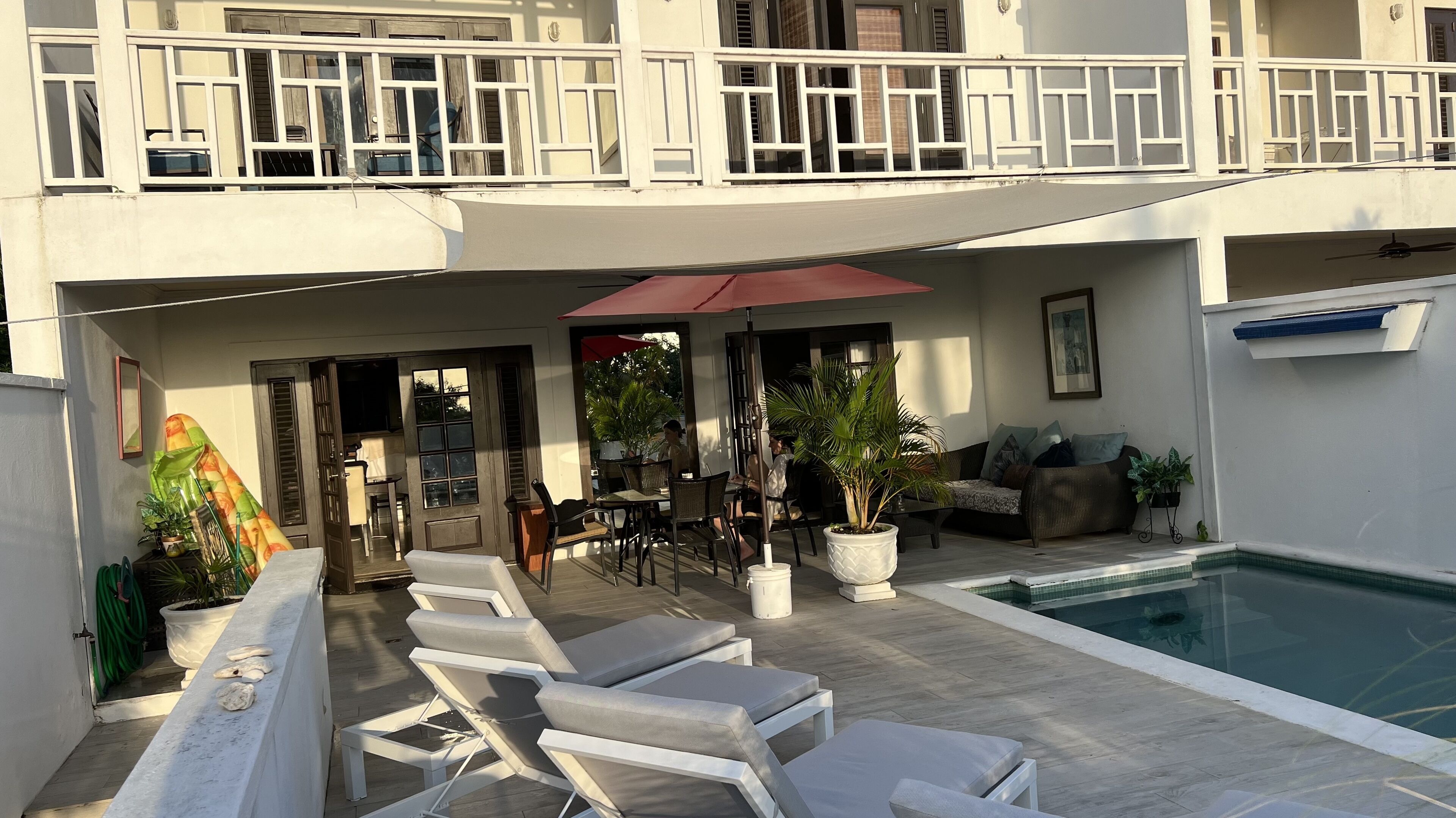 The pool terrace with sun loungers below the villa balconies.