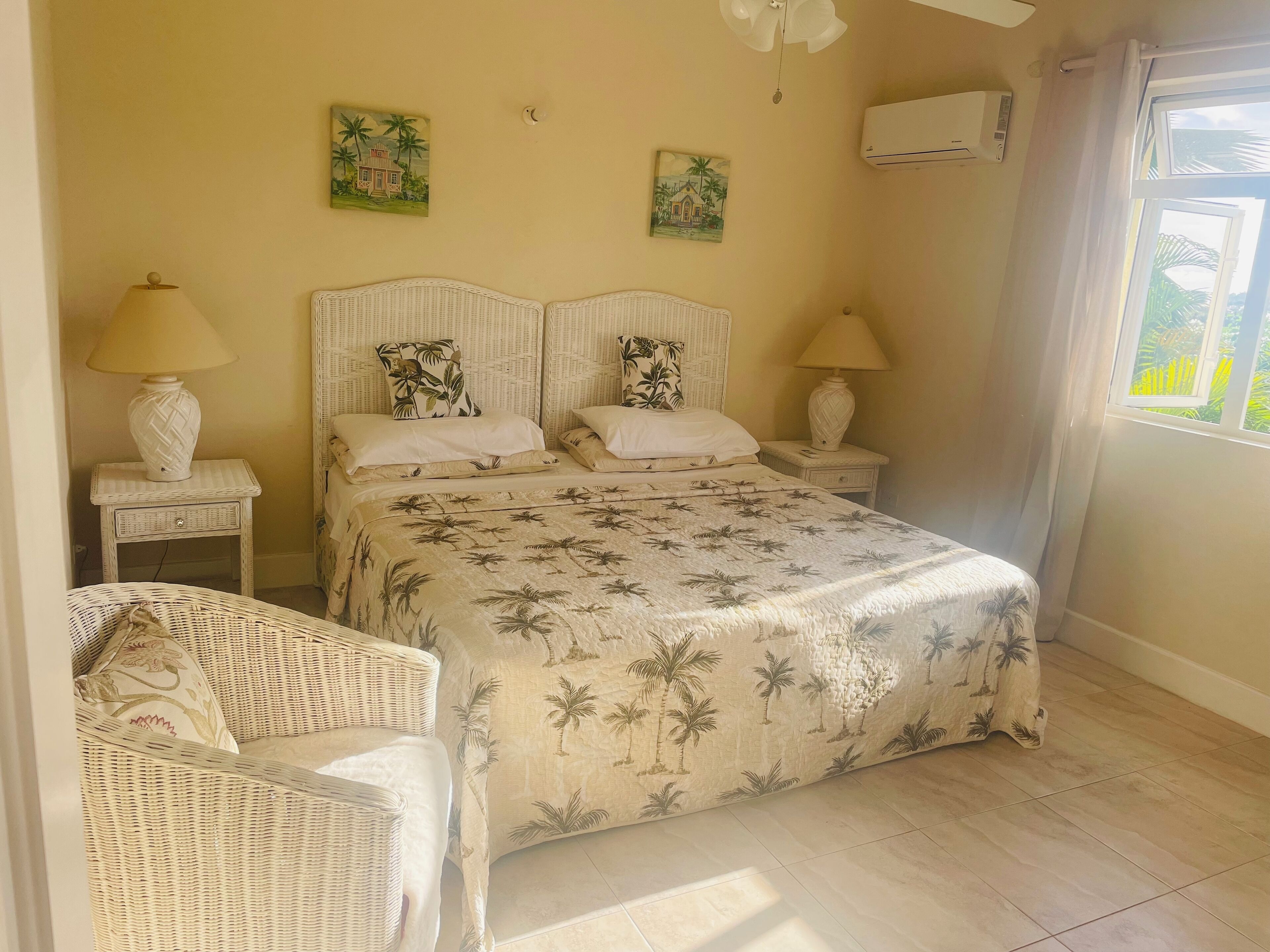 A bedroom with a double bed, two lamps, and an air-conditioning unit.