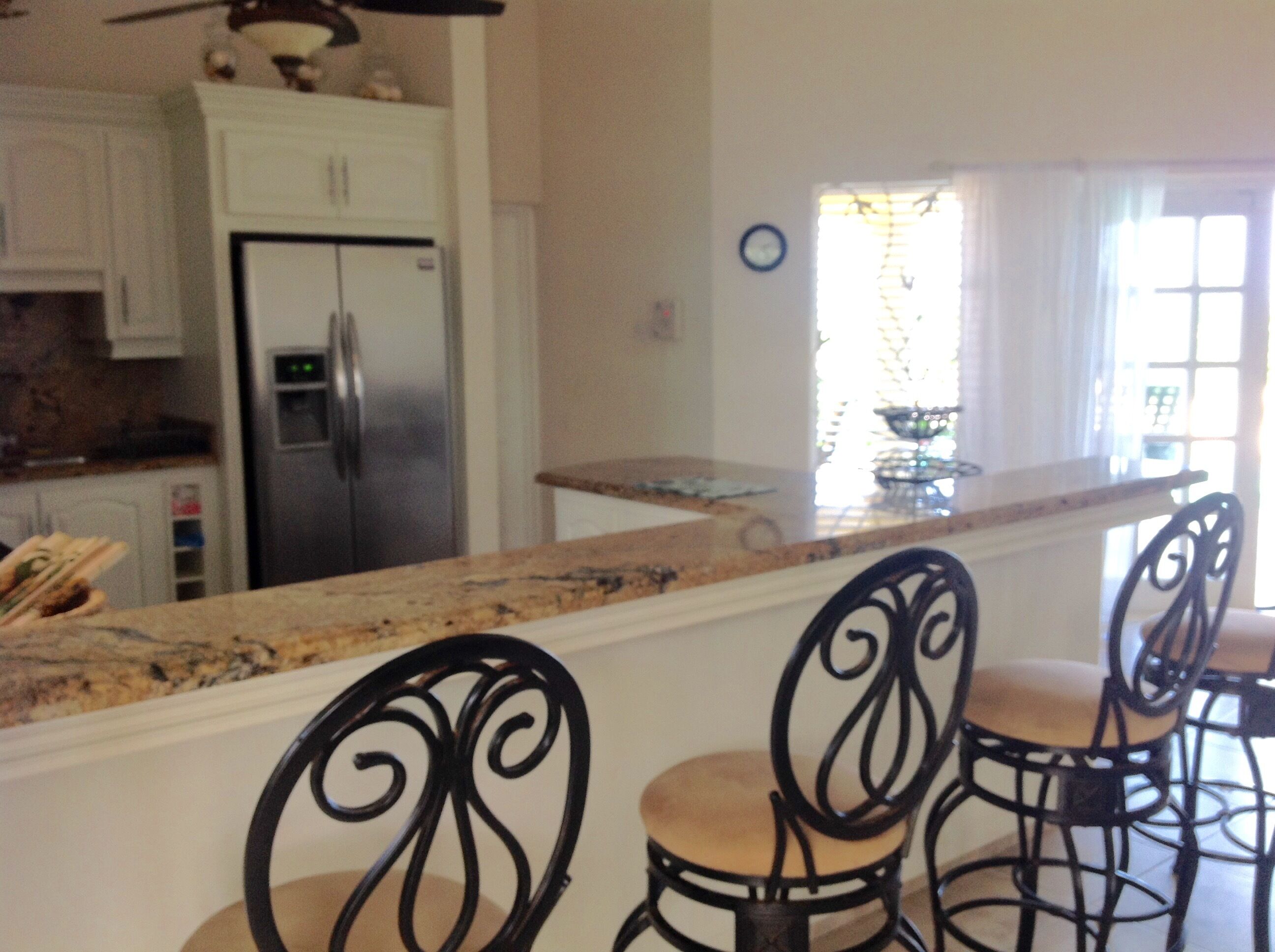 A view across the breakfast bar of the kitchen and the refrigerator.
