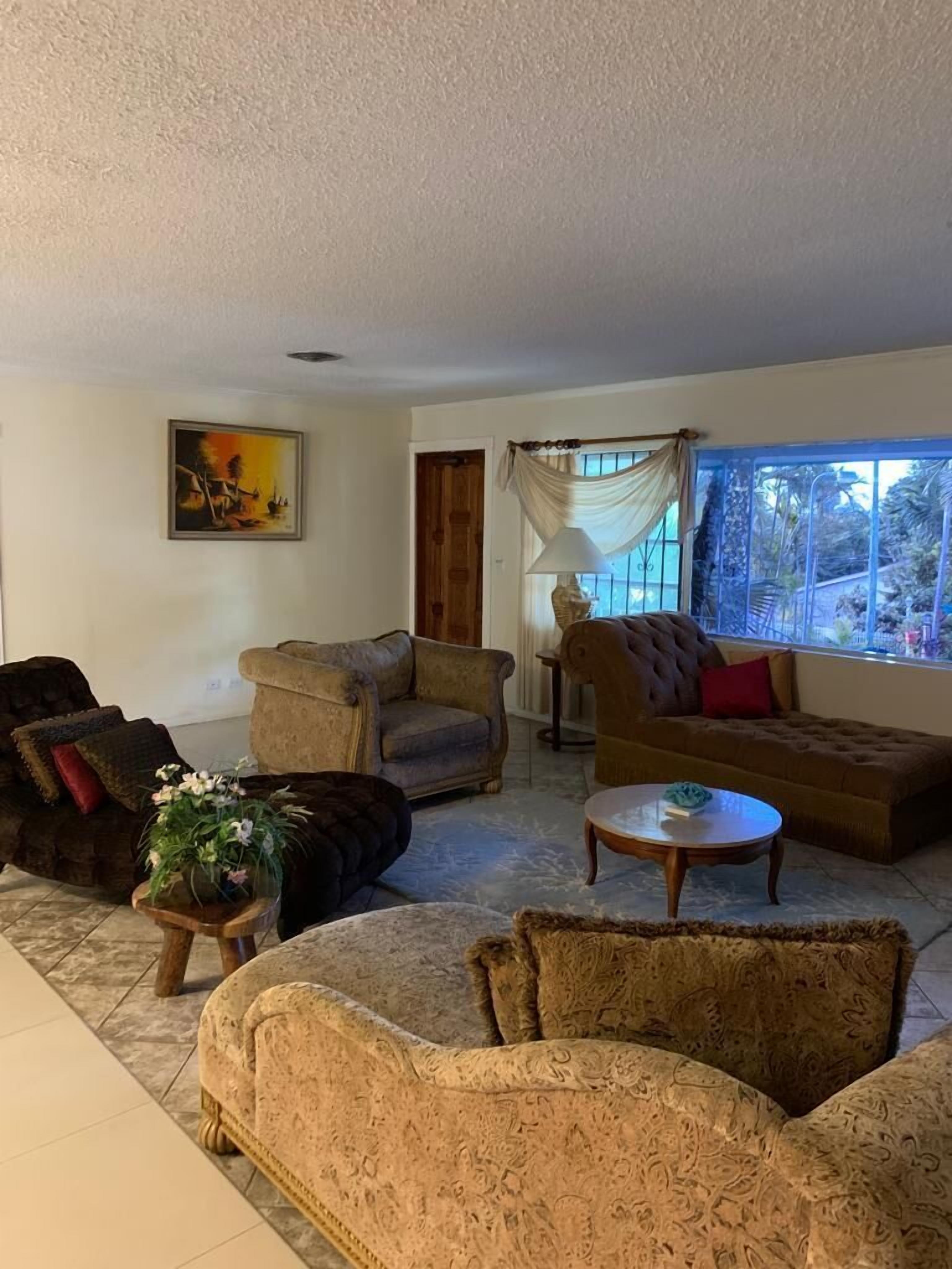 A living room with sofas and a large window.