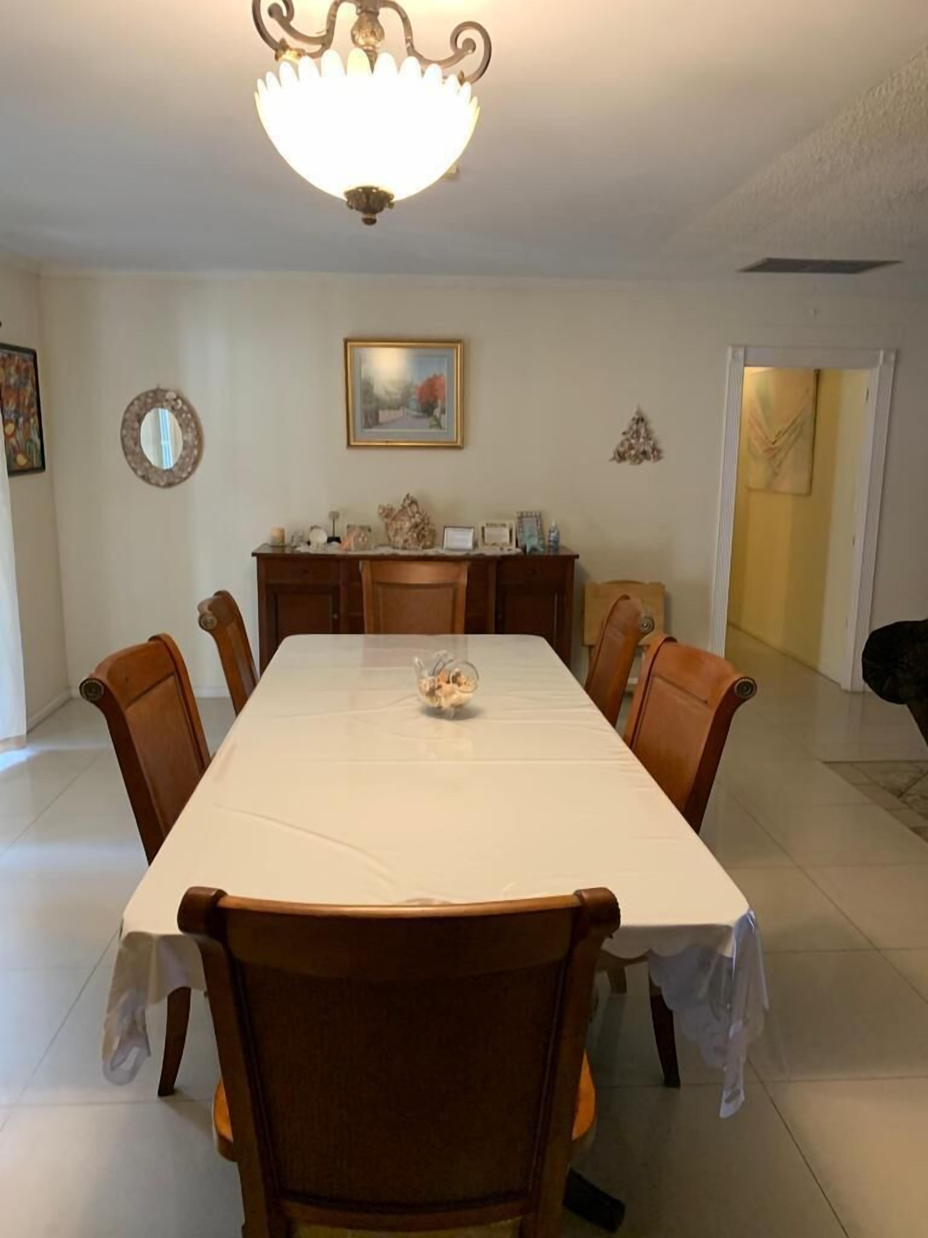 A dining room with a table and six chairs.