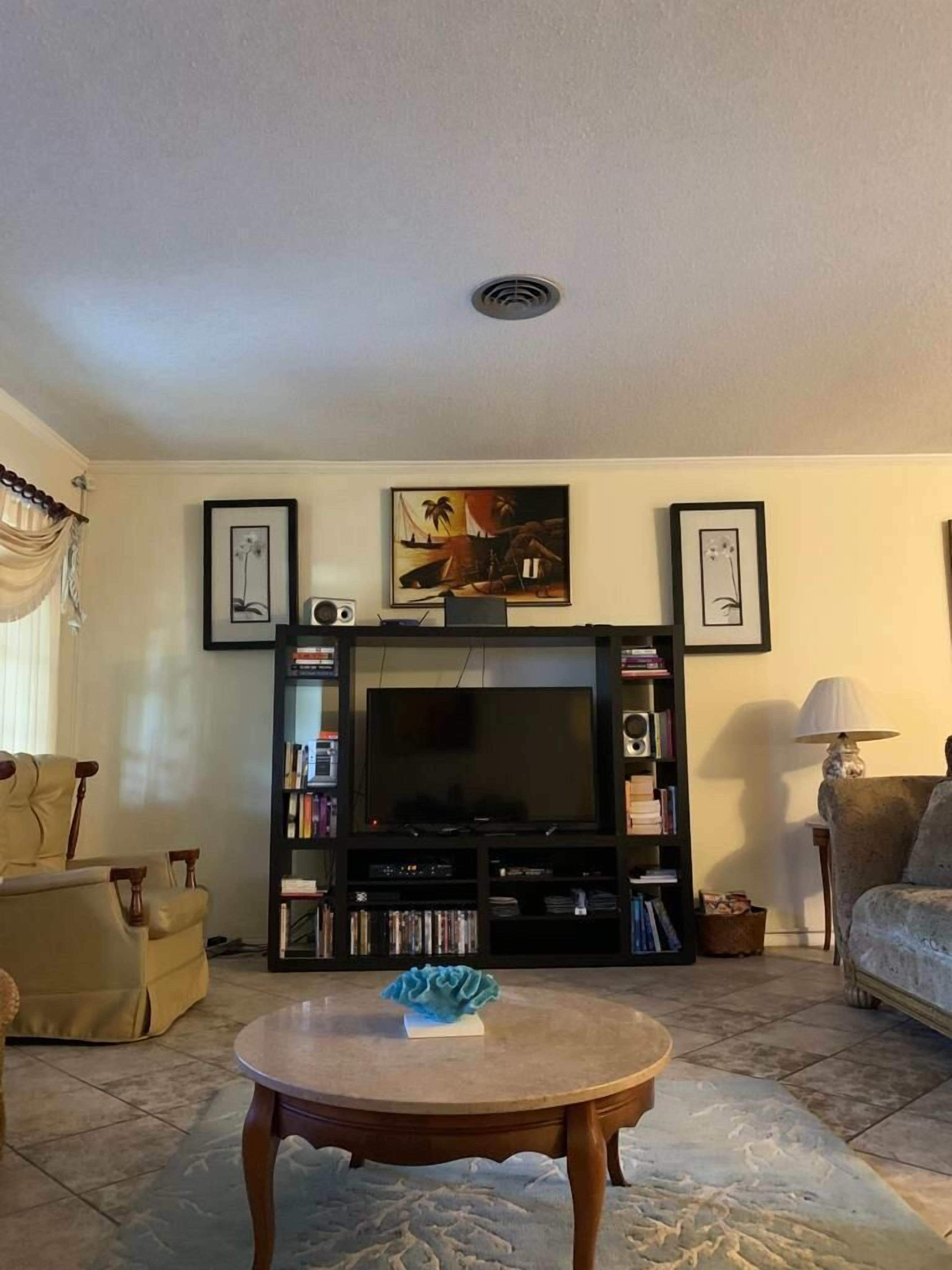 A living room with a television on a shelf unit.