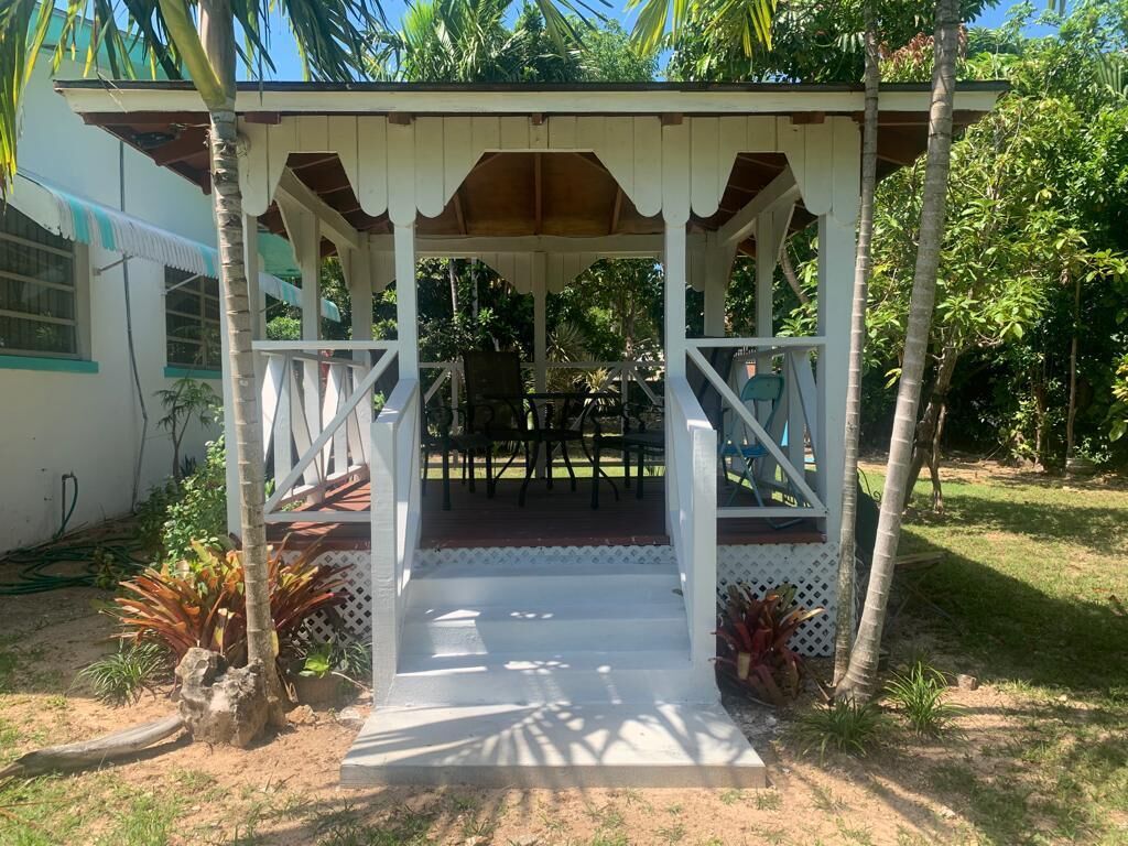 A gazebo with a table and chairs in the garden.
