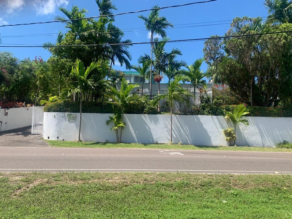 The white wall and the gate of the property from the road.