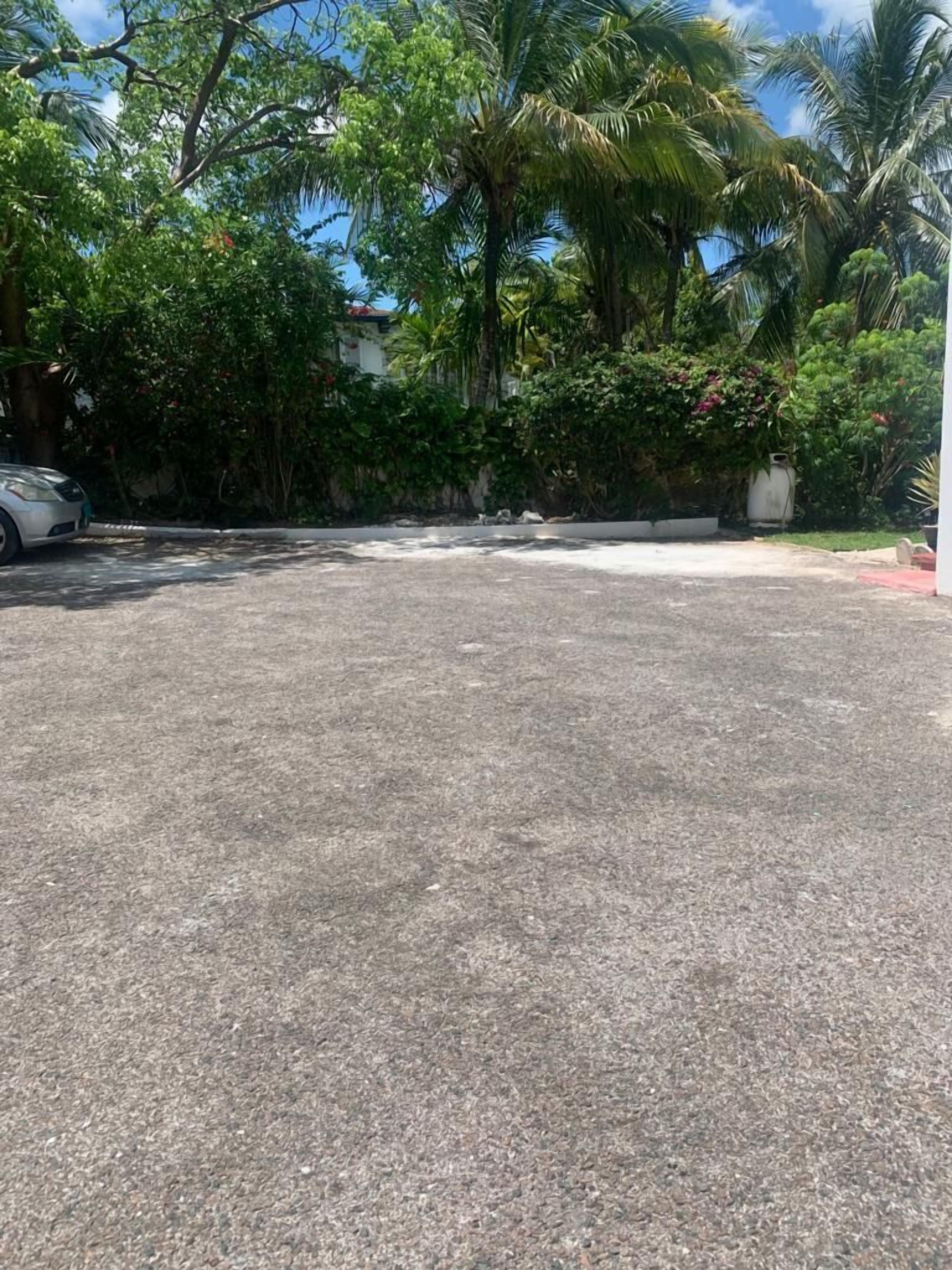 A gravel parking area with a car.
