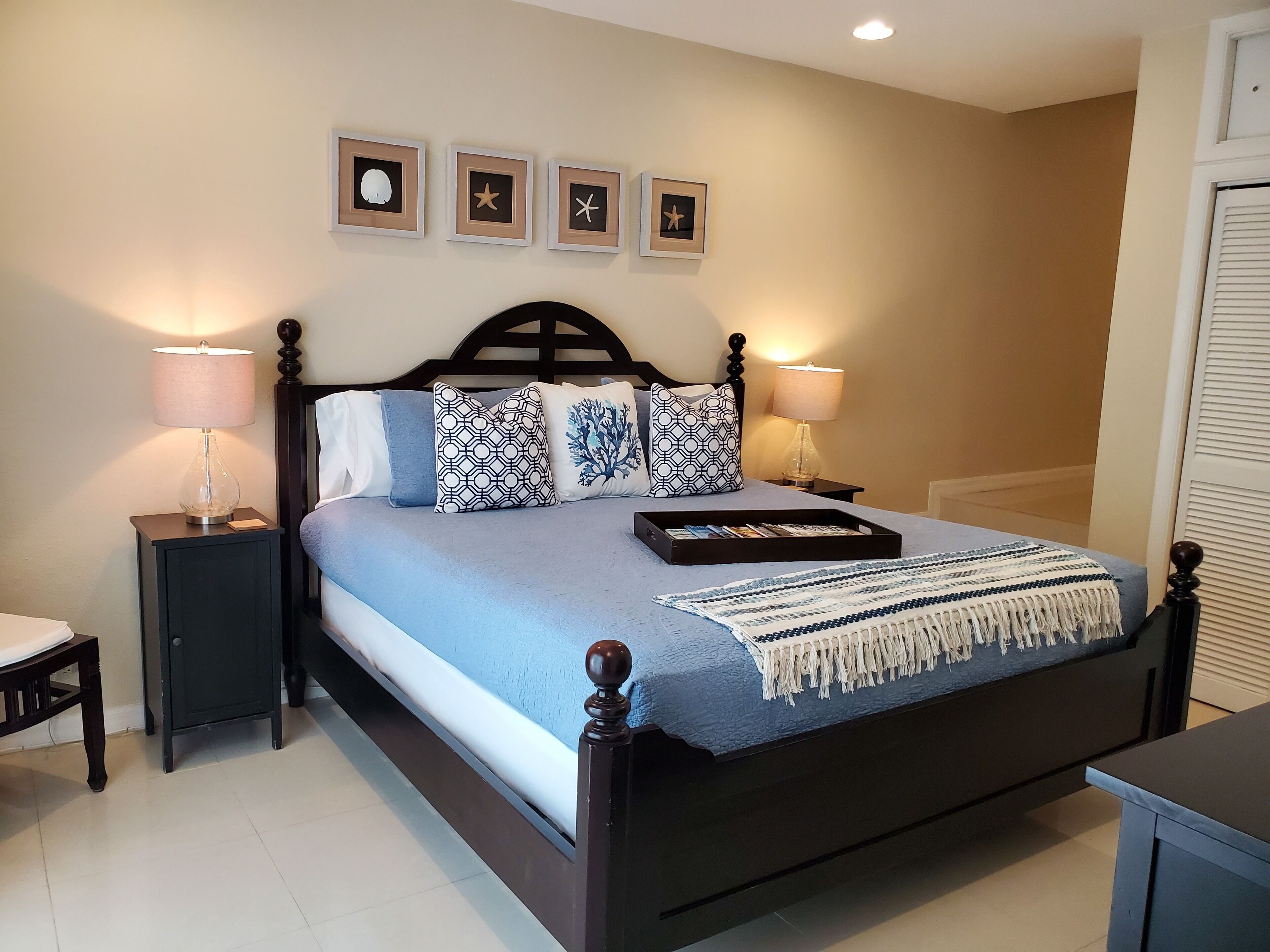A bedroom with a dark wood bed and a blue bedspread.