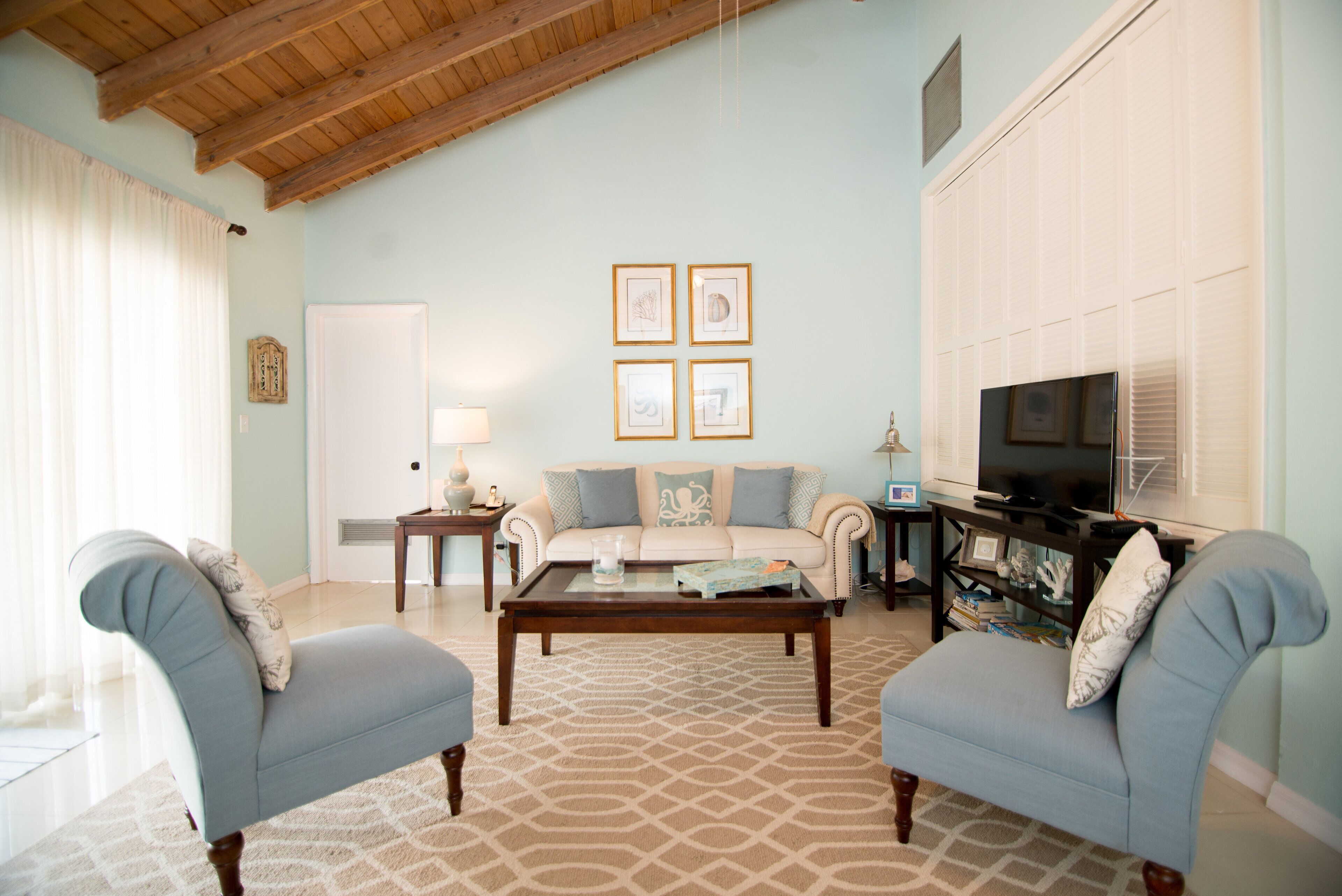 The living room with a sofa, two chairs, and a television.