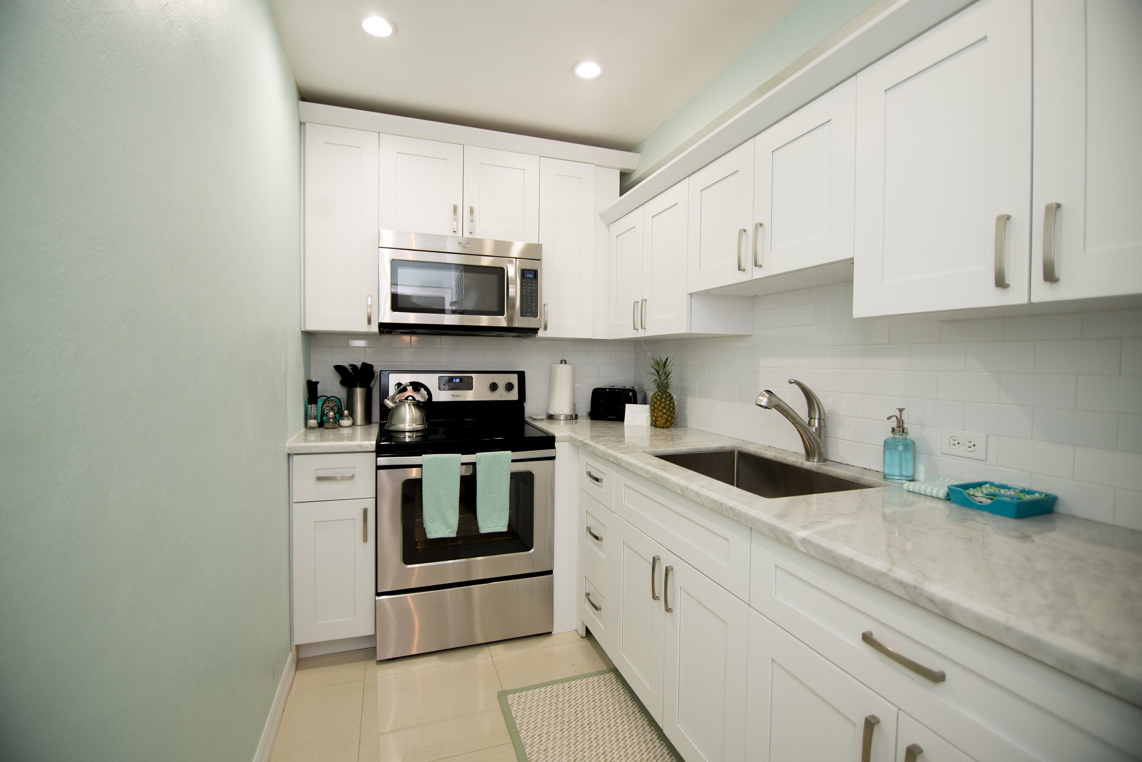 The kitchen with white cabinets and a stainless steel stove.