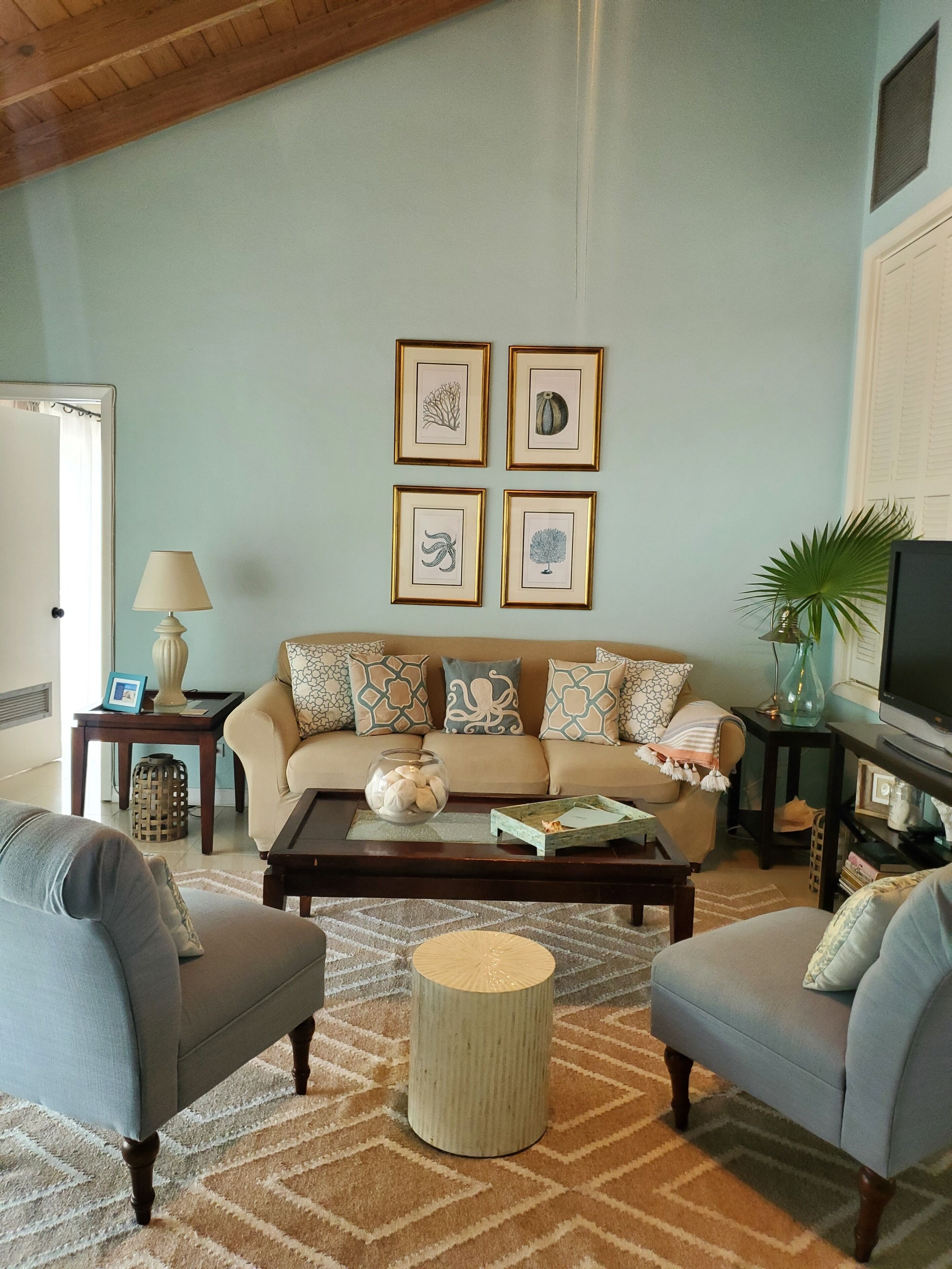 The living room with a sofa and four framed prints.