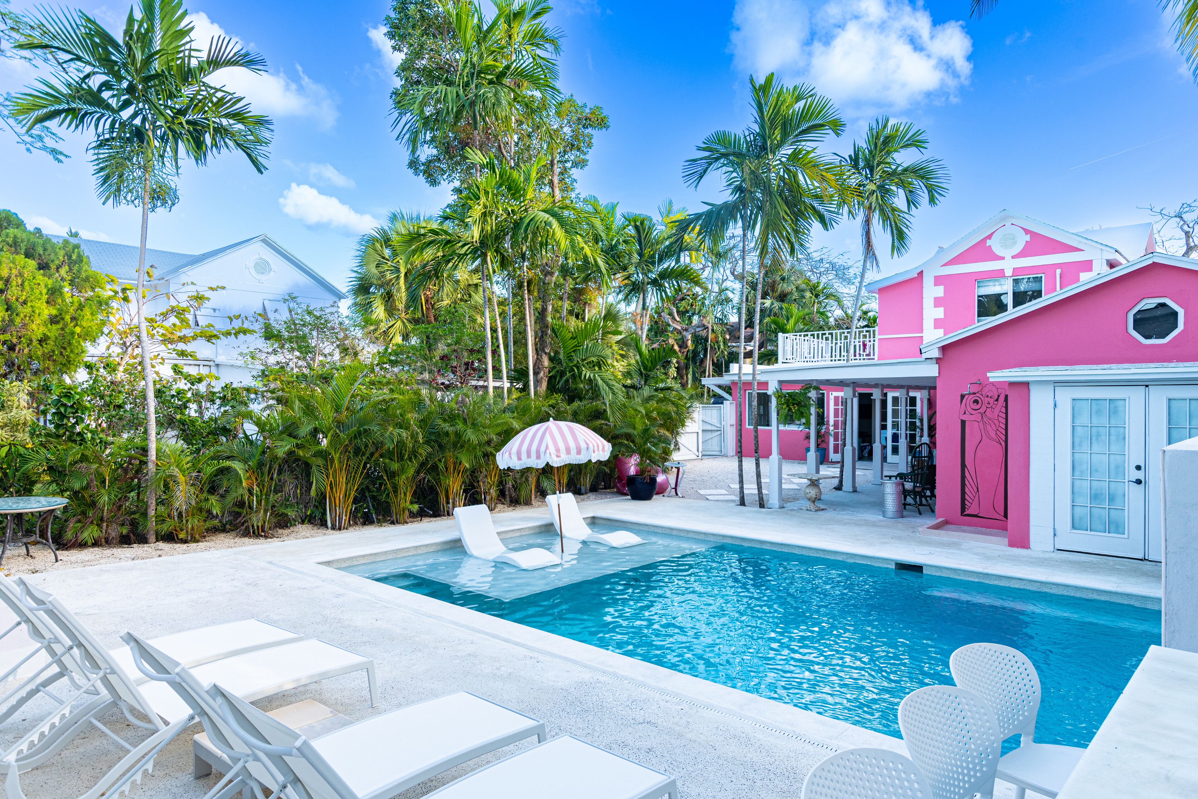 A view of the pool and the pink two-story villa.