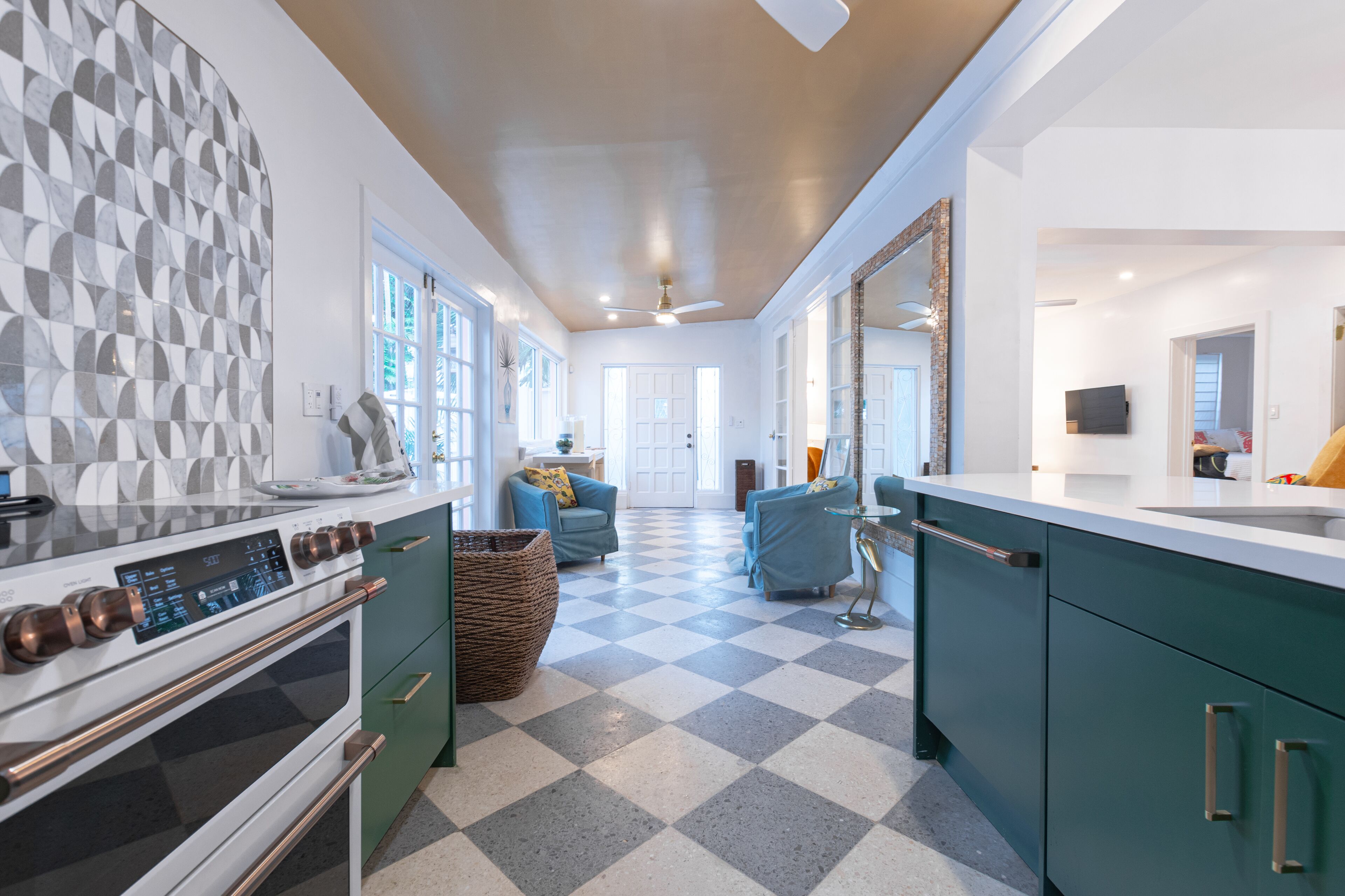 The kitchen with green cabinets and a checkered floor.
