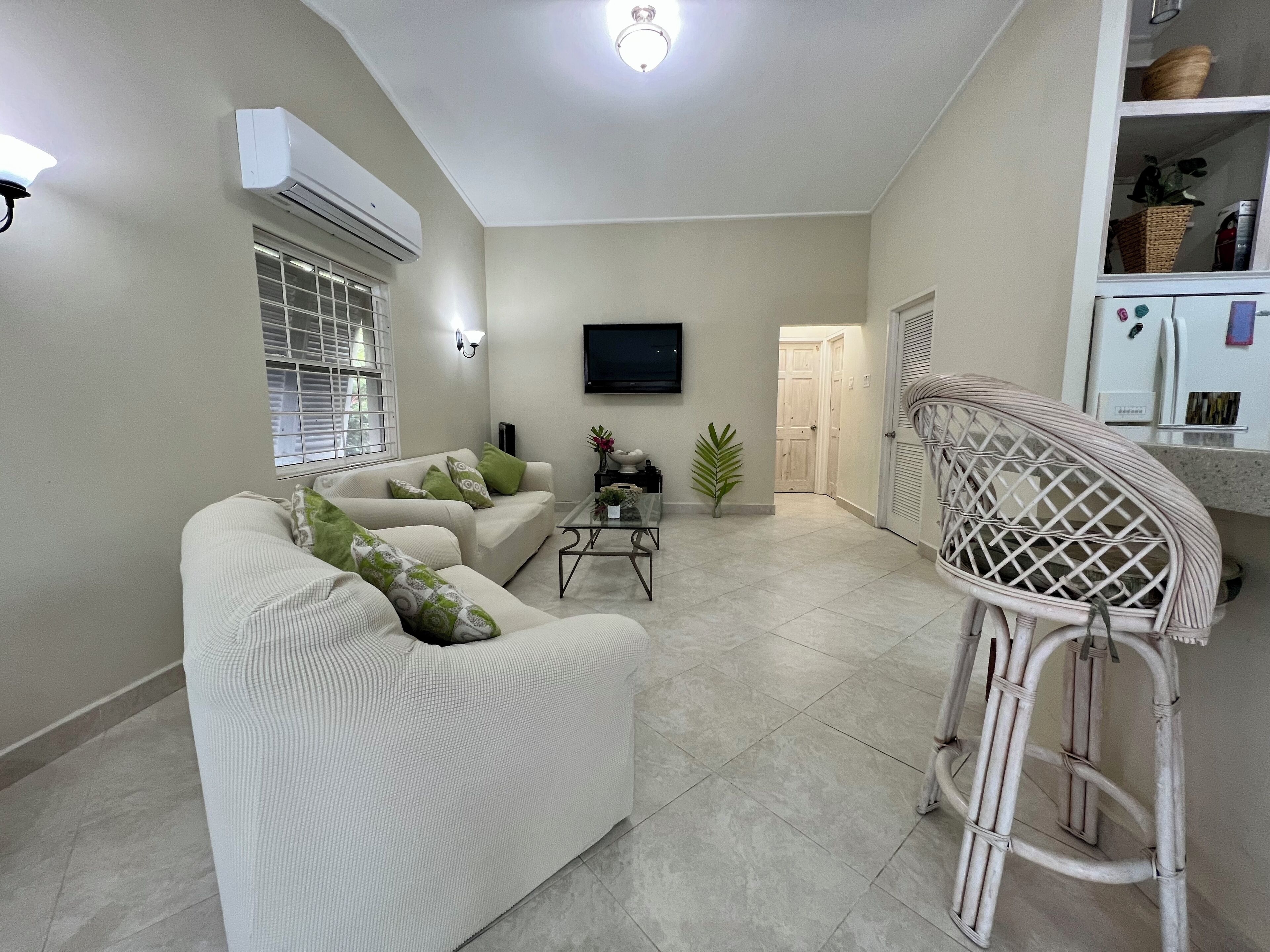 A living room with two sofas and a wall-mounted television.