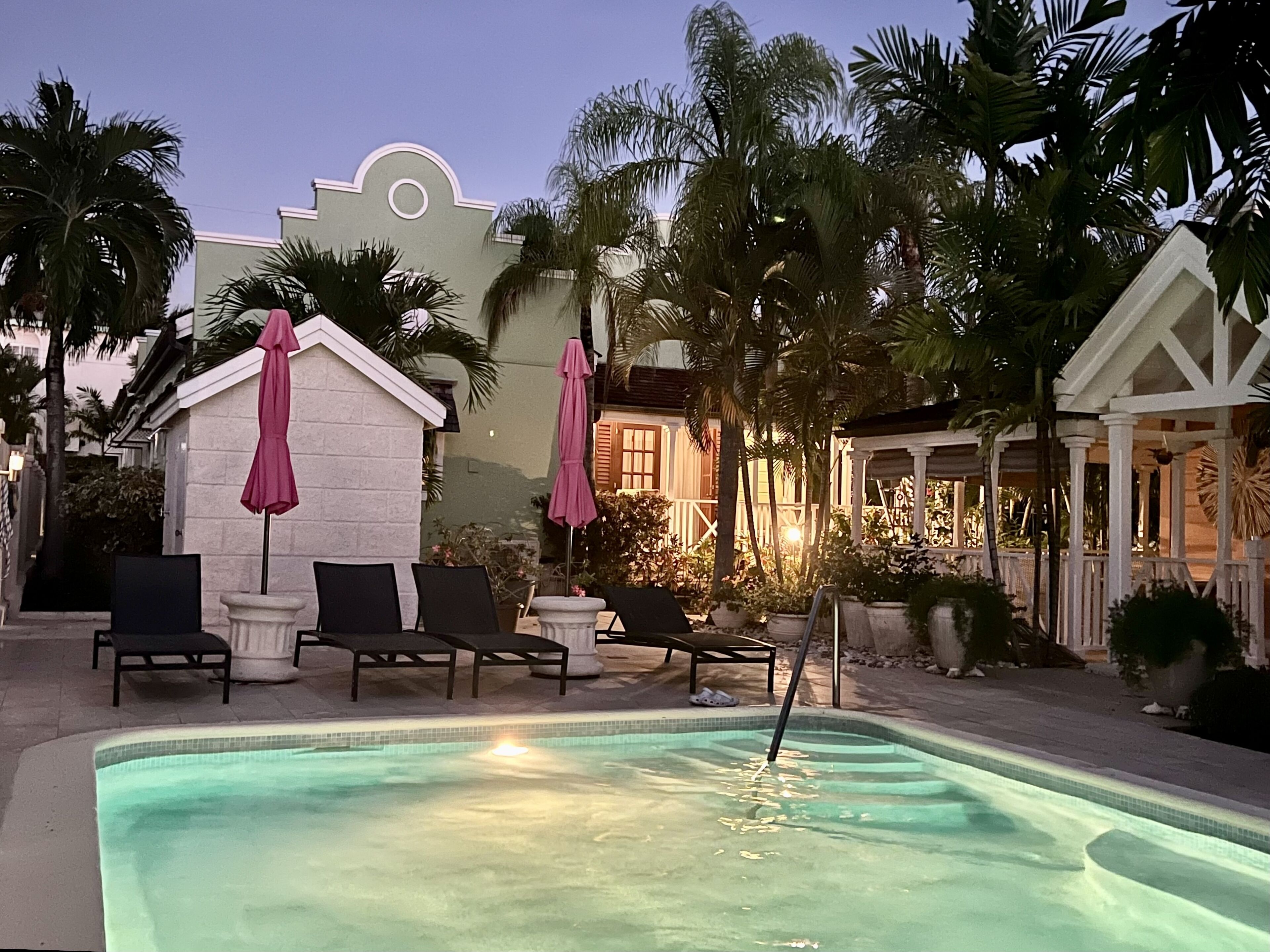 The pool with sun loungers and pink umbrellas in the evening.