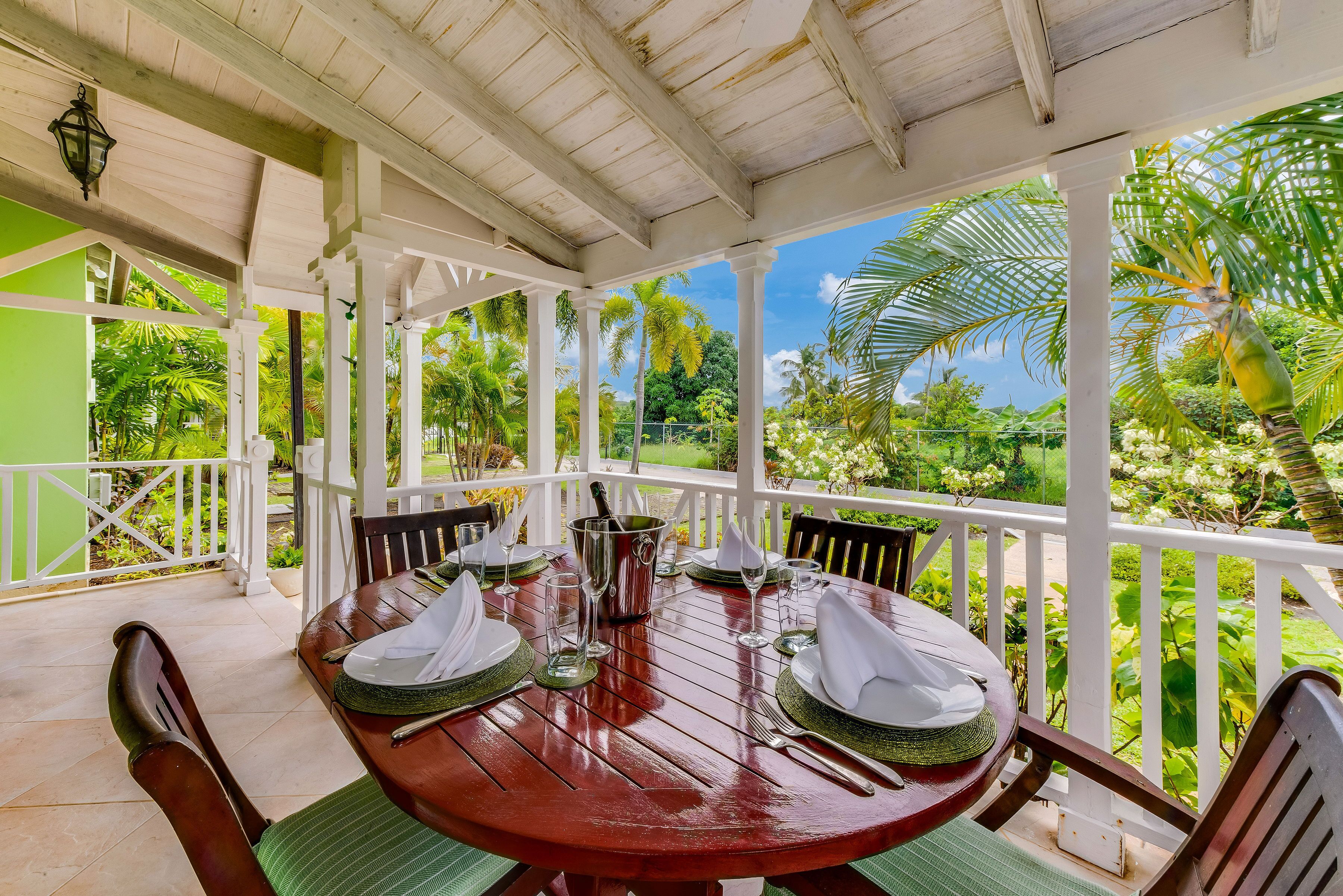 A covered veranda with a dining table set for 4.