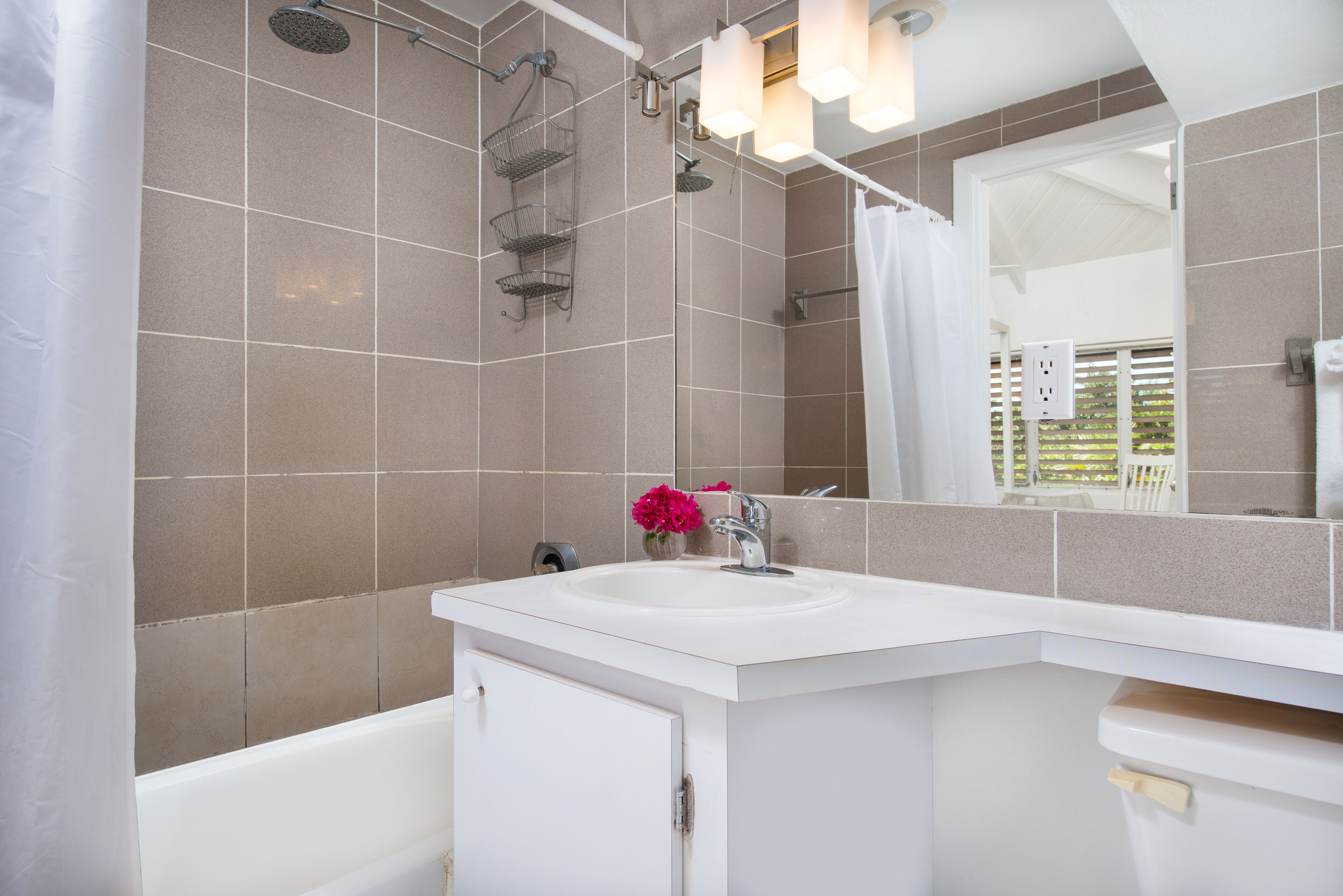 A bathroom with a bathtub, a sink, and a mirror.