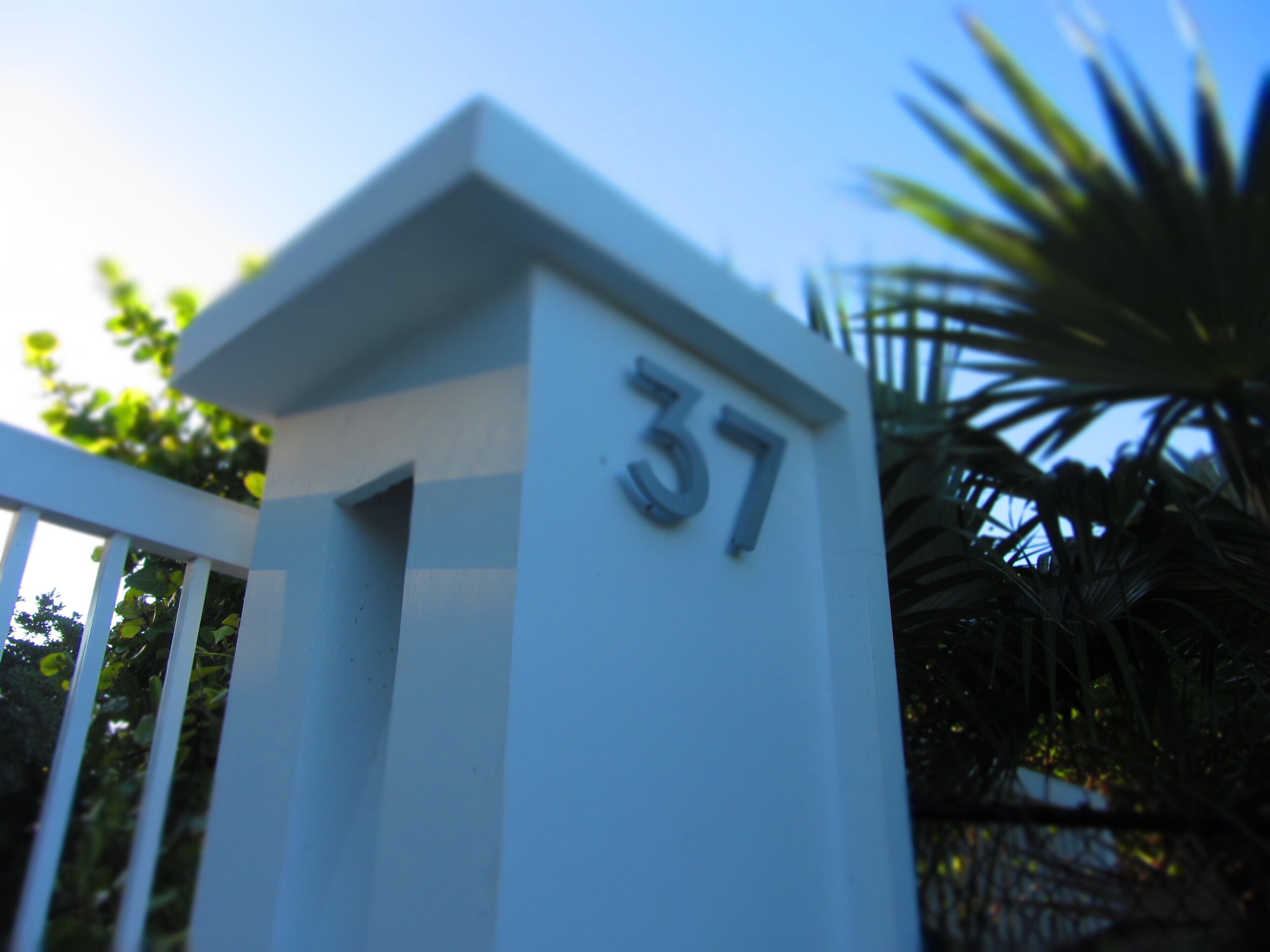 A white gate pillar with the number 37.