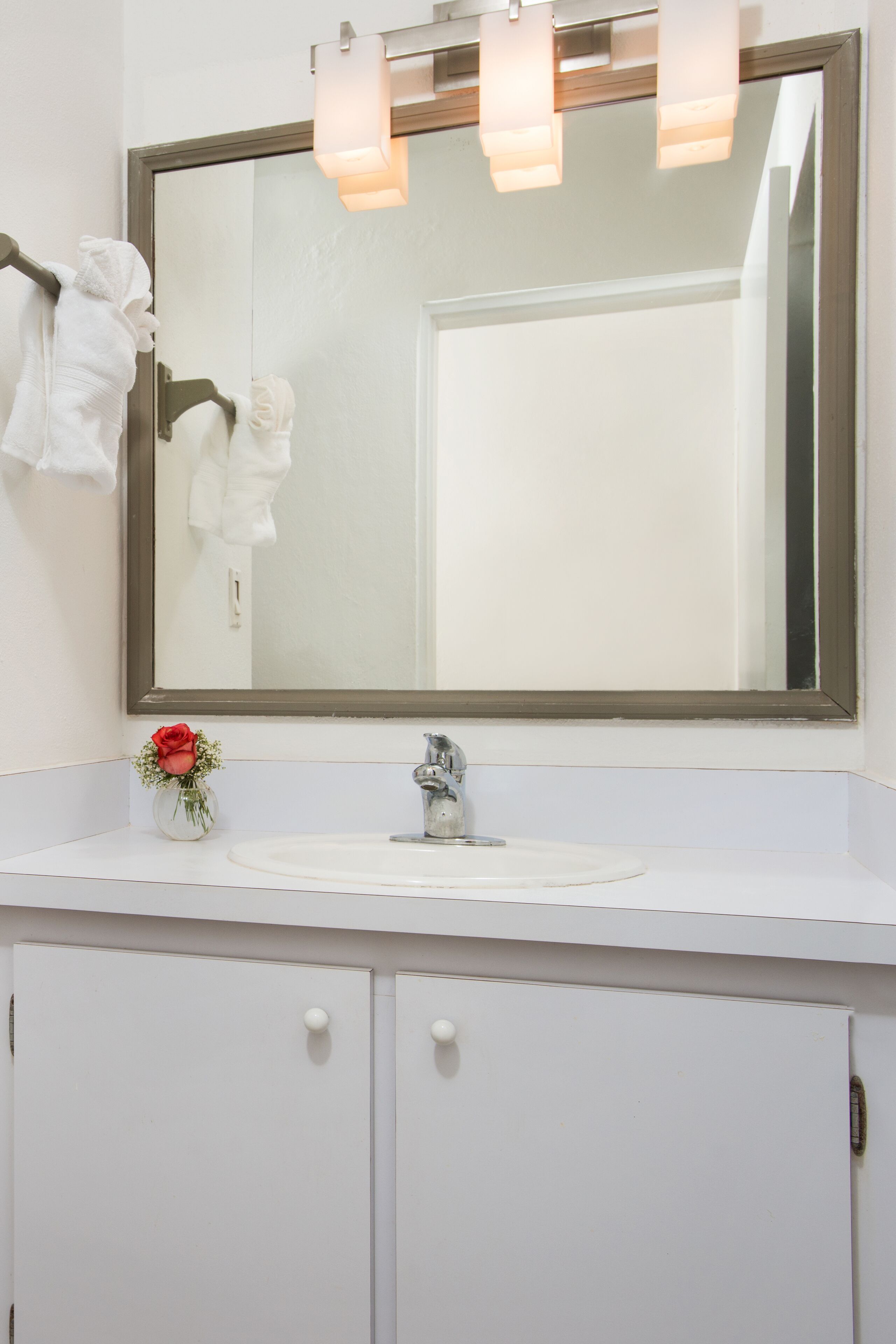 A bathroom sink with a mirror and towels.