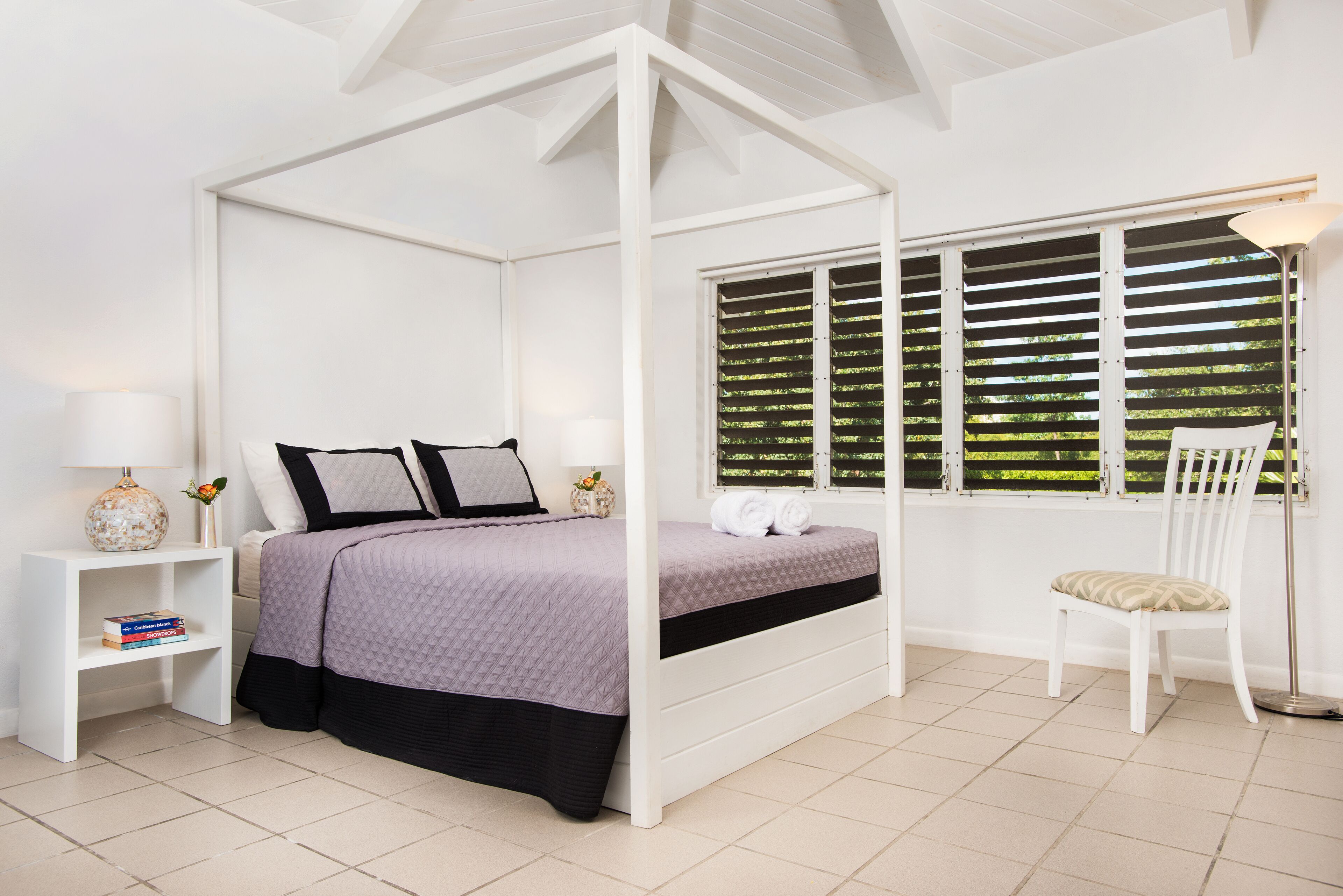 A four-poster bed with a gray cover.