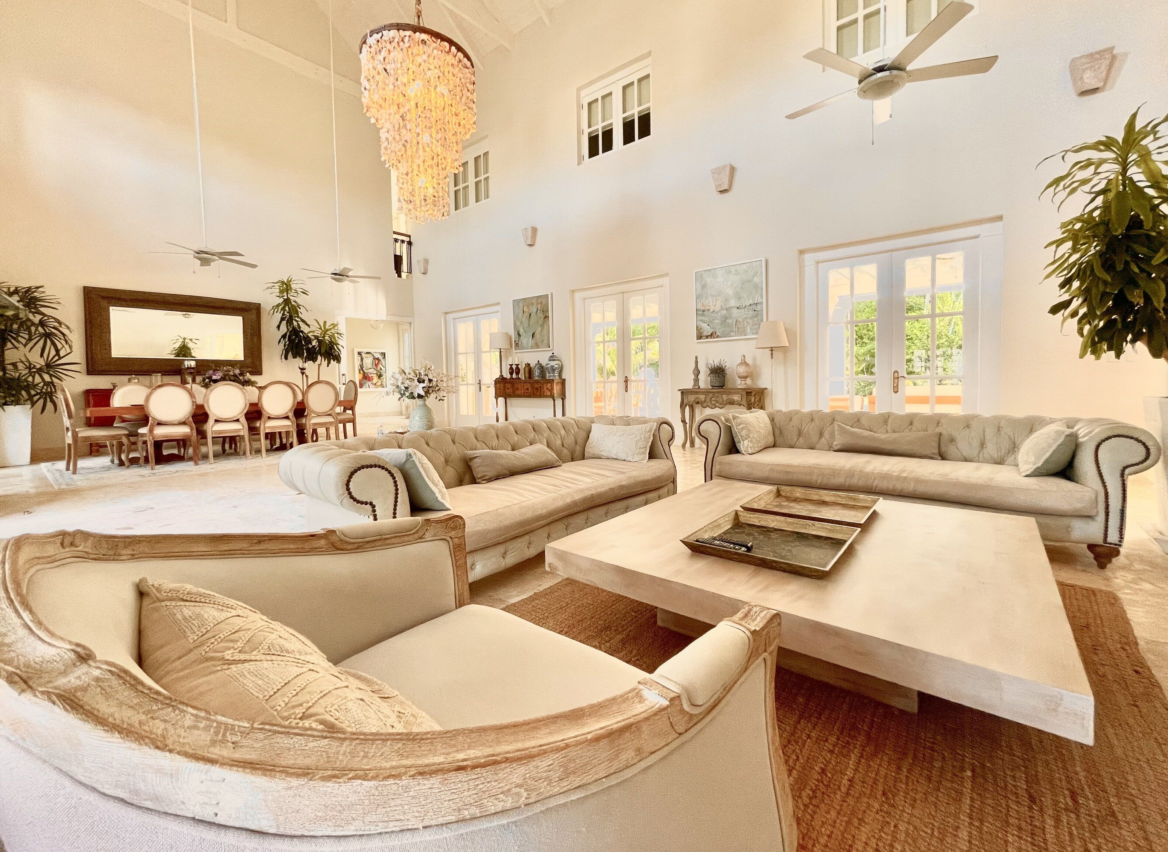 A living room with three sofas, a wooden coffee table, and wall art.
