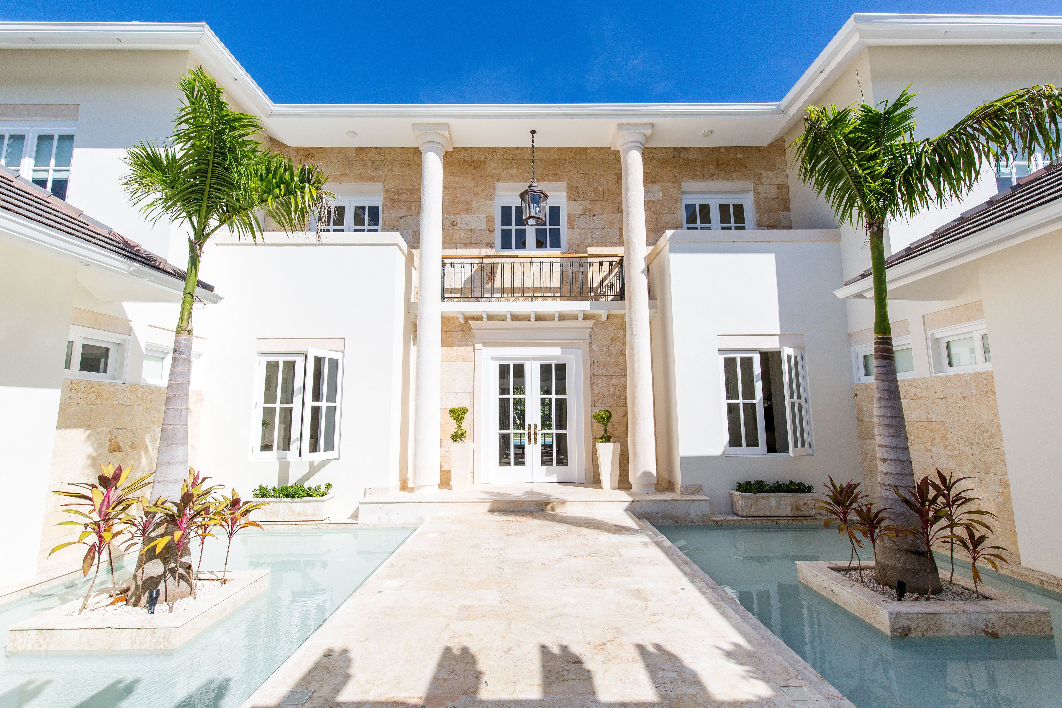 A walkway between columns and water features at the villa entrance.