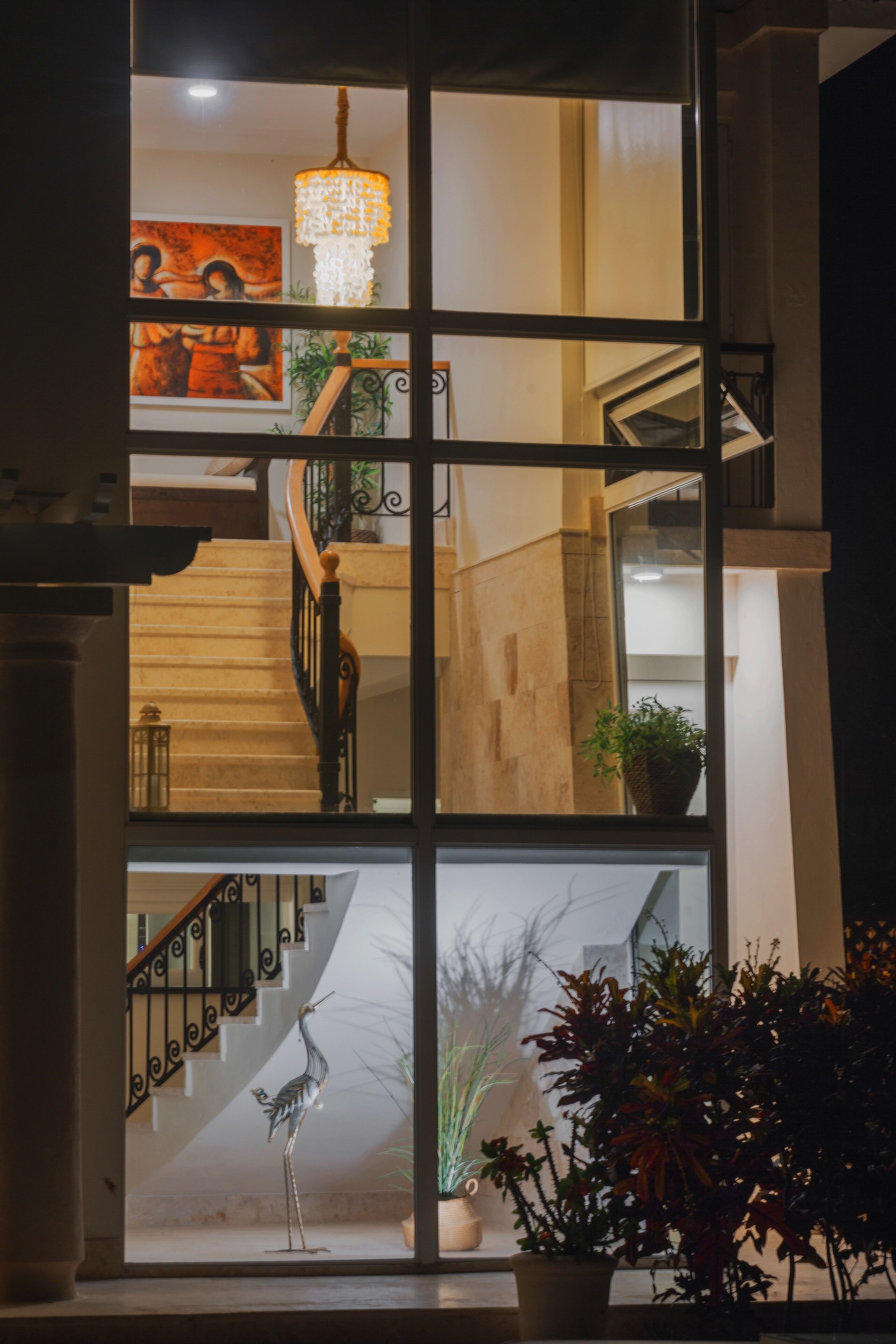 A view through a tall window of the staircase at night.