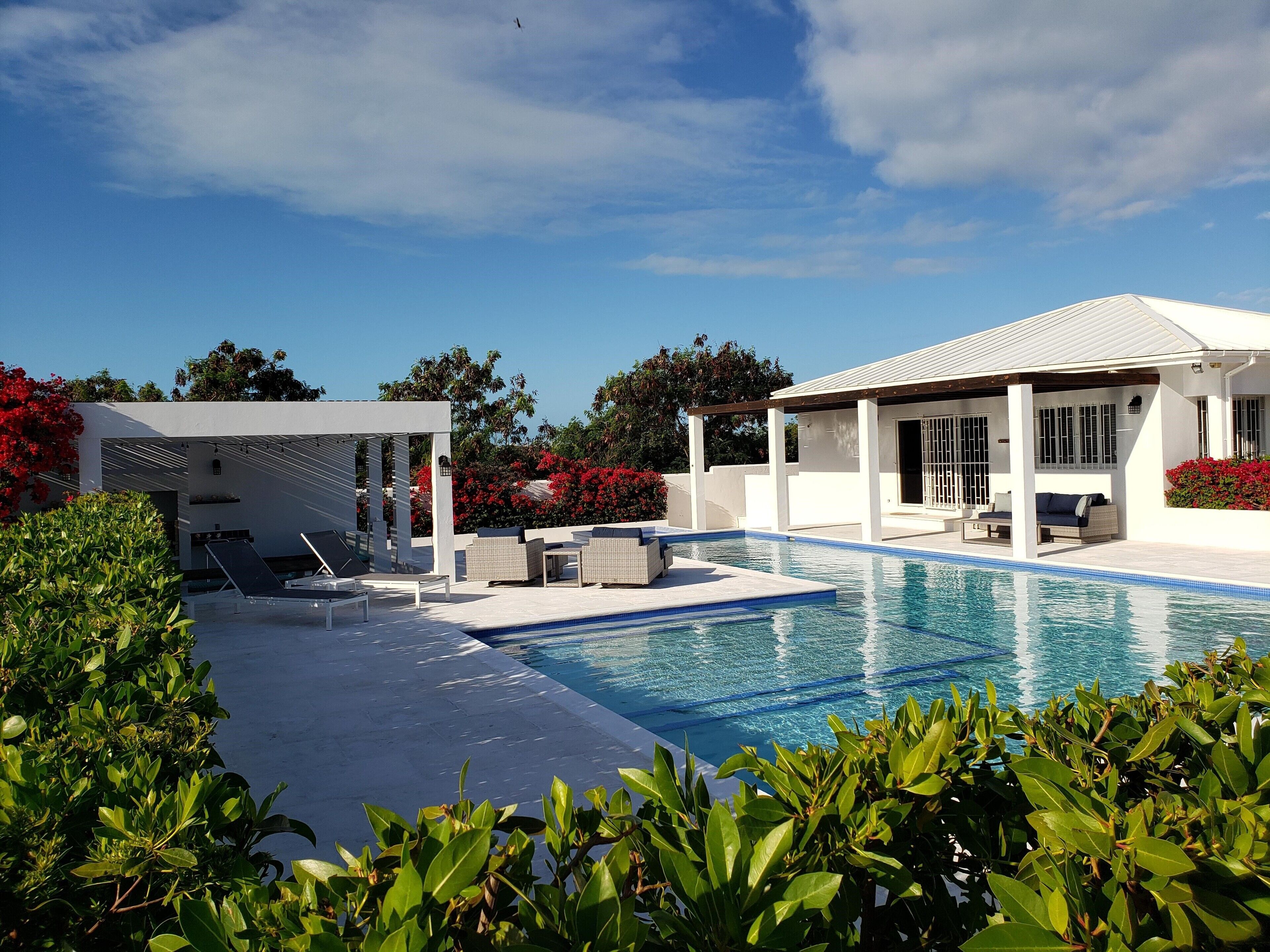 The pool and the villa under a blue sky.
