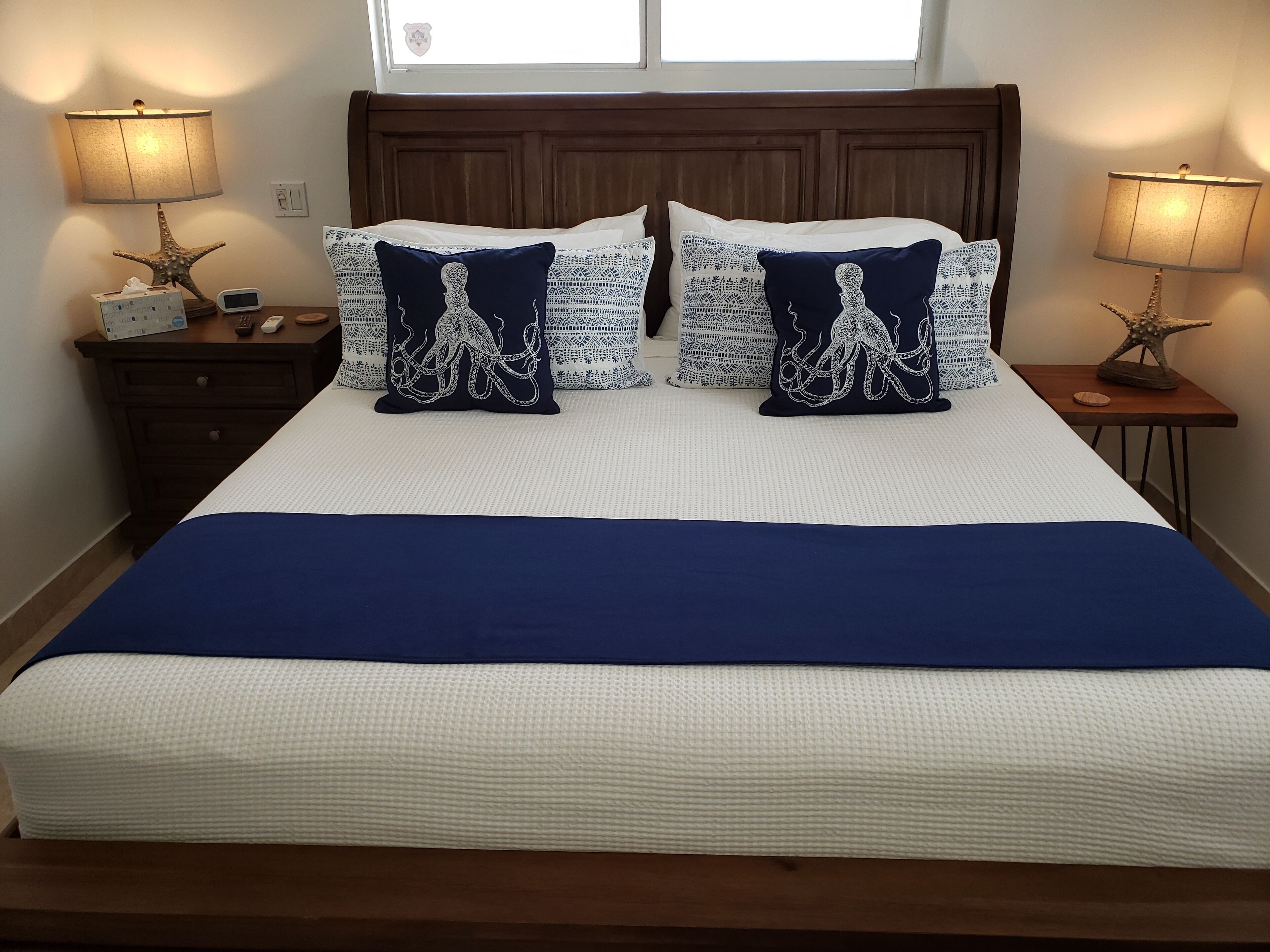A bedroom with a wood bed and blue and white bedding.