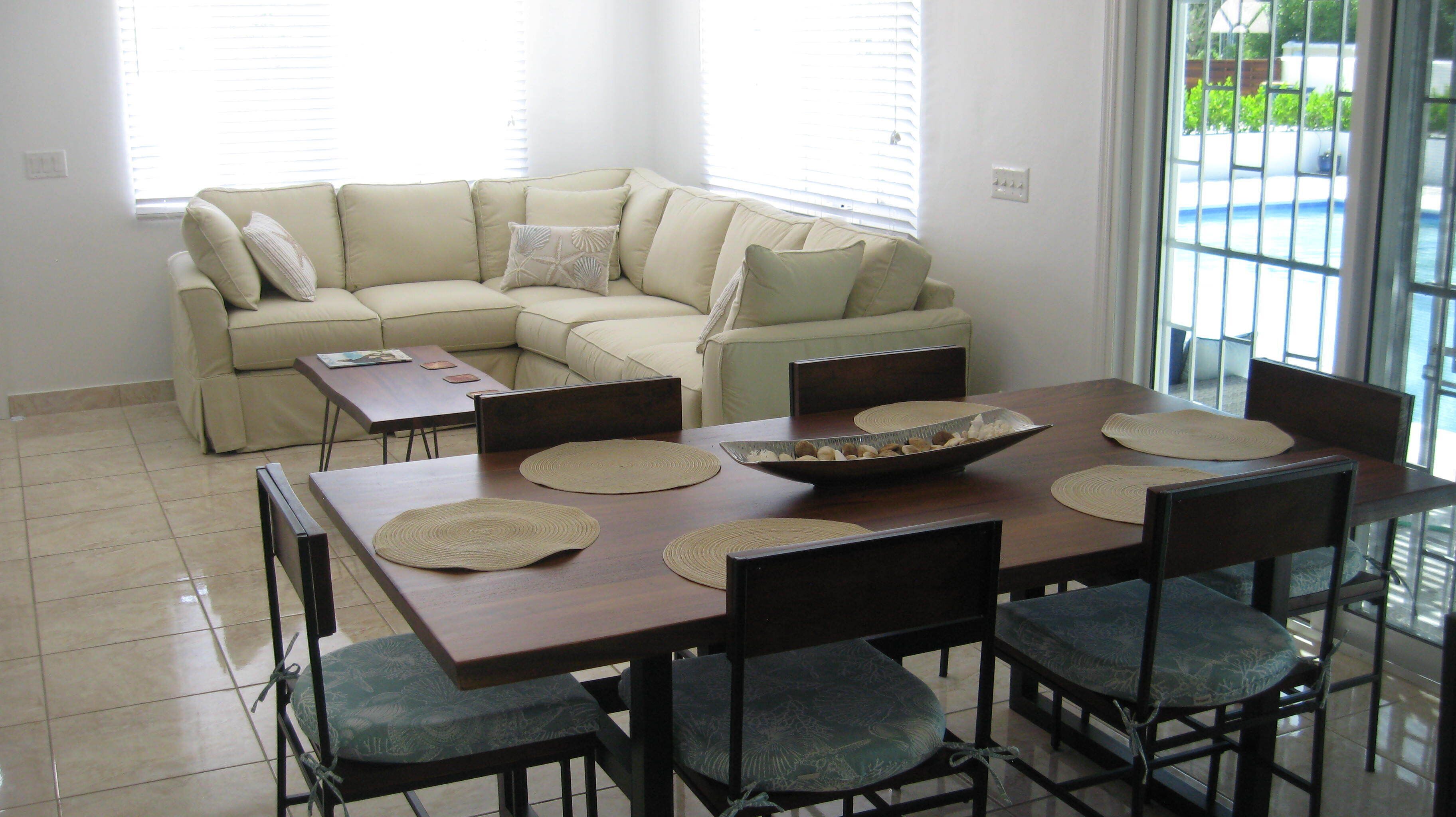 A living area with a corner sofa and a dining table.